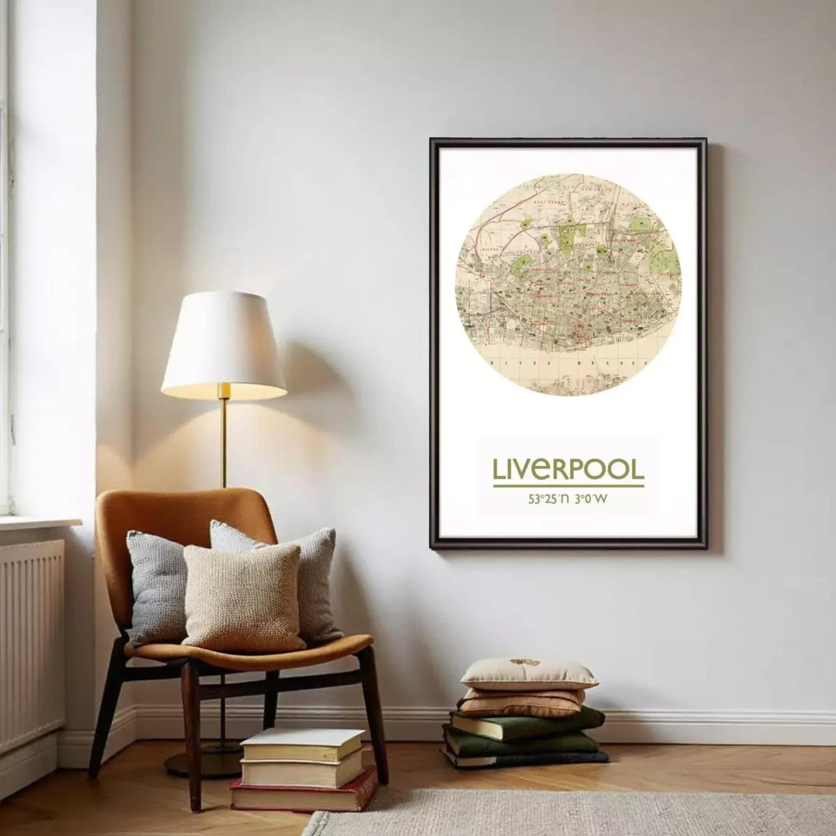 a framed map of Liverpool, with a lamp and a stack of books on the floor in front of it.