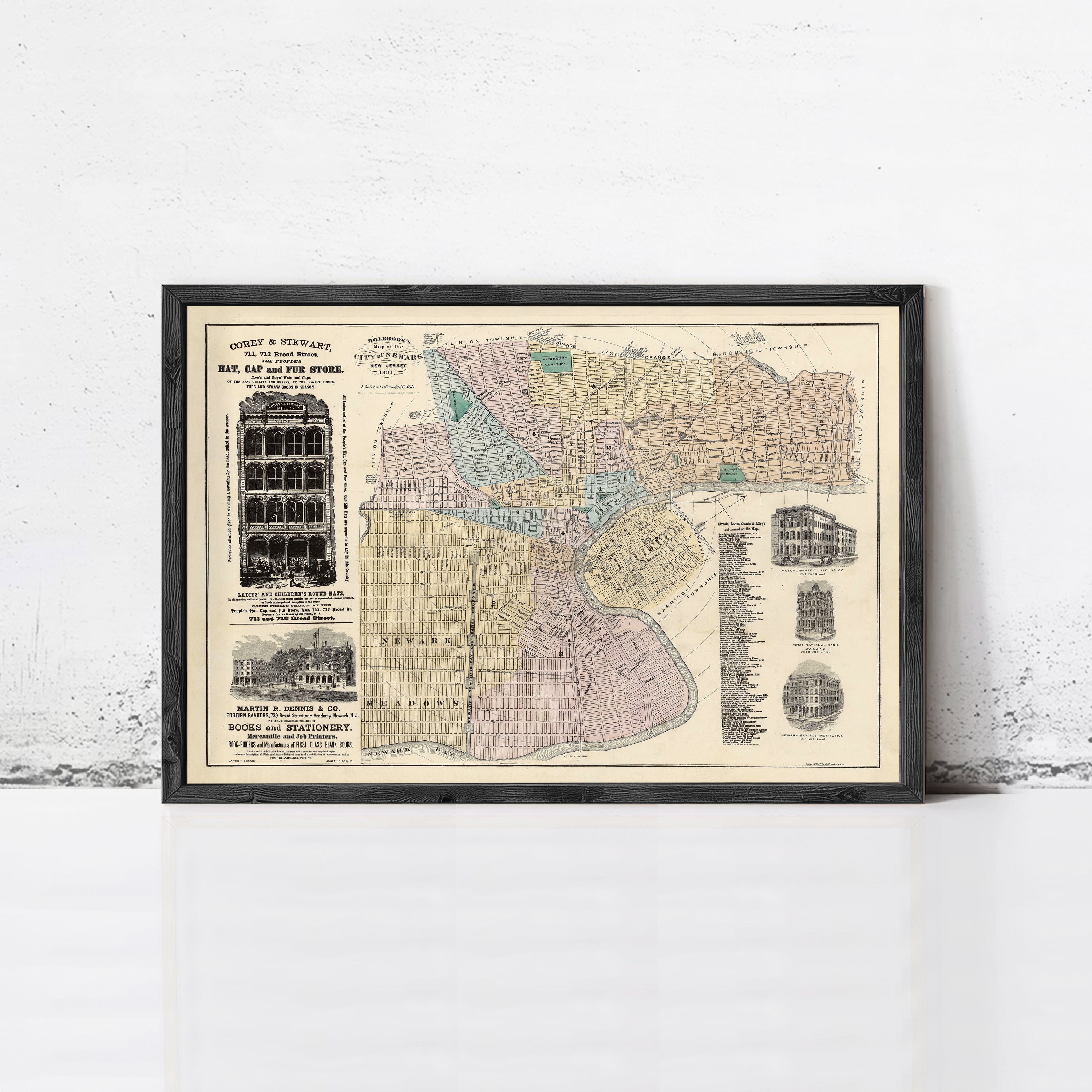 The image is a framed vintage map of a city, likely from the early 20th century, depicting various buildings and streets.