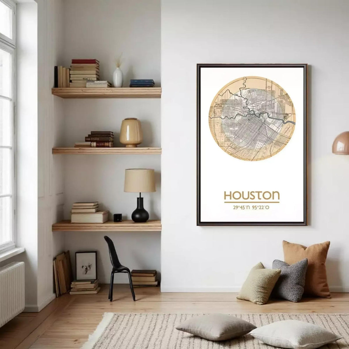 a cozy living room with a large framed map of Houston hanging on the wall. The room has a bookshelf filled with books, a chair, and a lamp. There are also some decorative pillows on the floor.