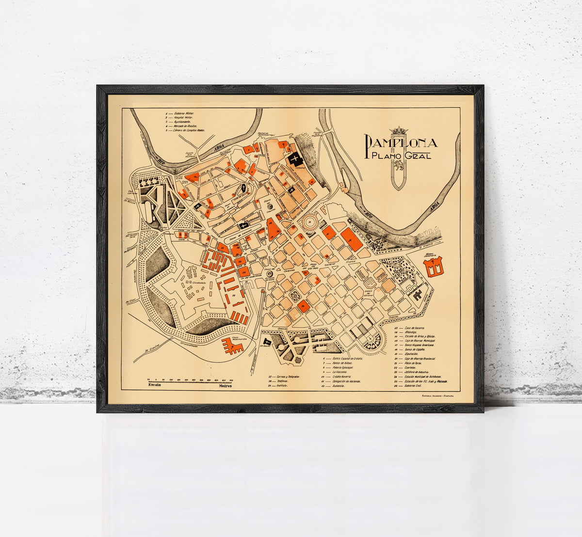 The image is a framed map of the city of Pamplona, Spain, depicting the layout and various landmarks within the city.