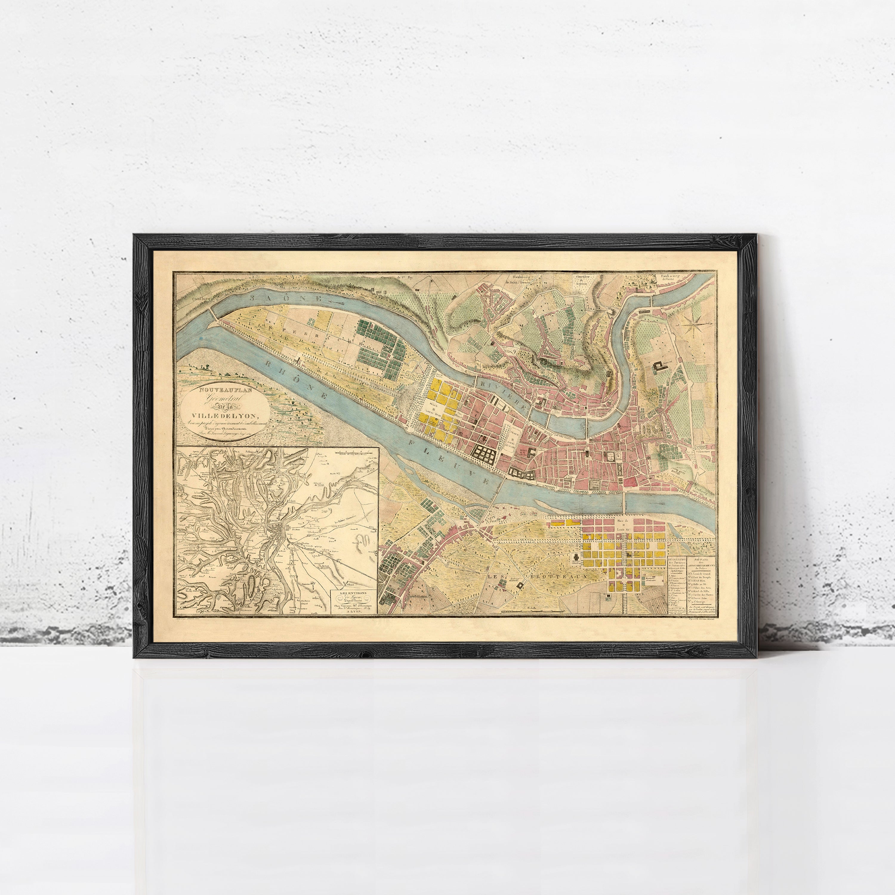 The image is a framed vintage map of a city, depicting a detailed layout of streets, buildings, and other urban features.