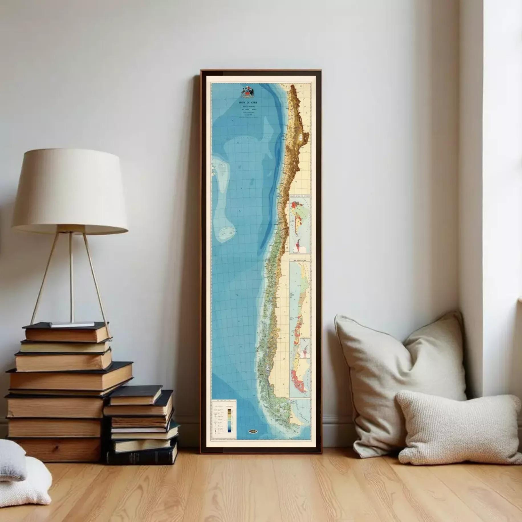 a tall, narrow framed map of South America, specifically Chile, standing against a white wall.