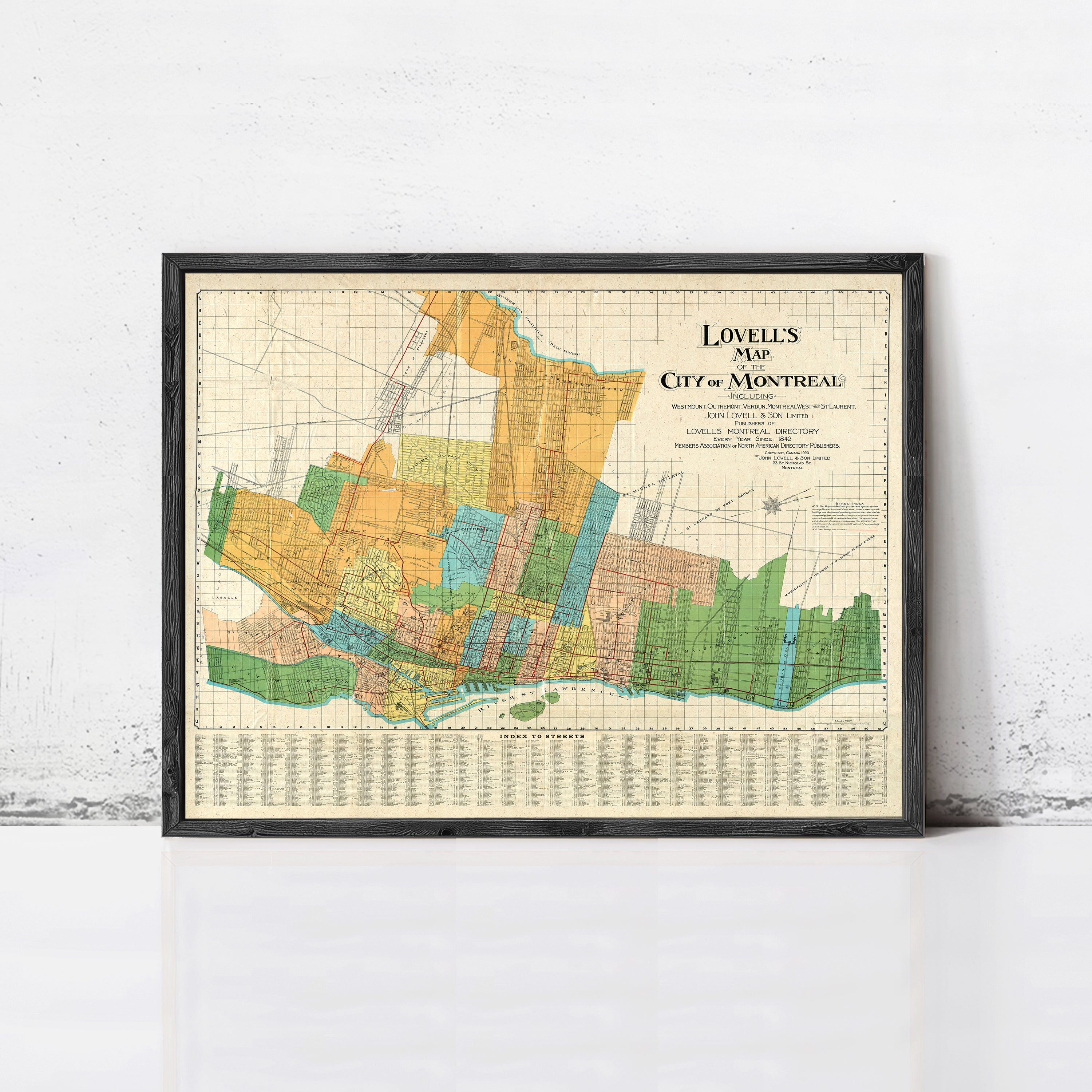 The image is a framed map of the city of Montreal, Canada, with various colored sections representing different neighborhoods and areas within the city.