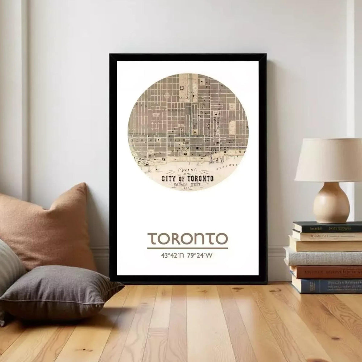 A framed poster of a map of Toronto, with the text "TORONTO" and the location "43°42'49" N 79°24'49" W" printed on it.