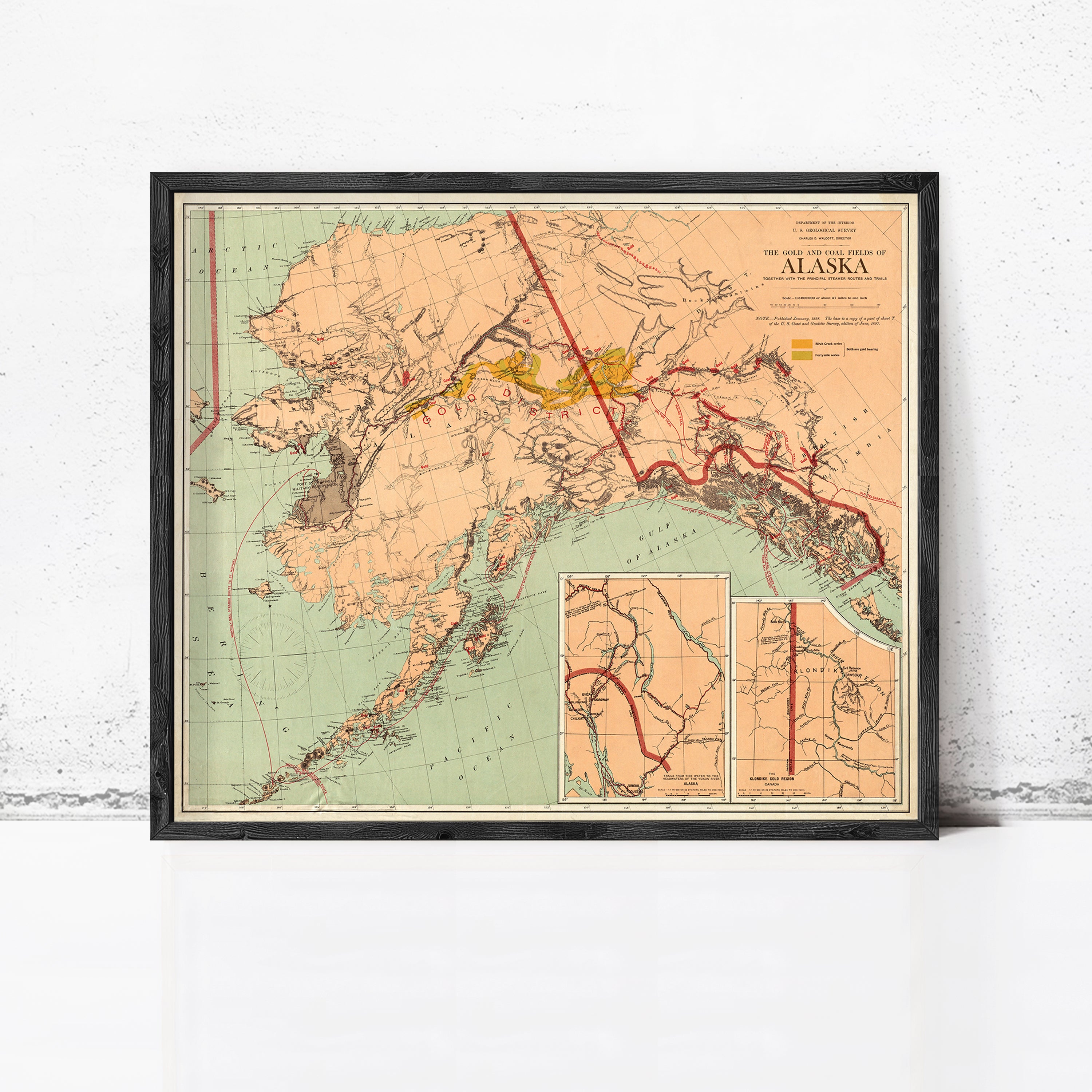 The image is a framed vintage map of Alaska, depicting the state's geographical layout and surrounding areas.
