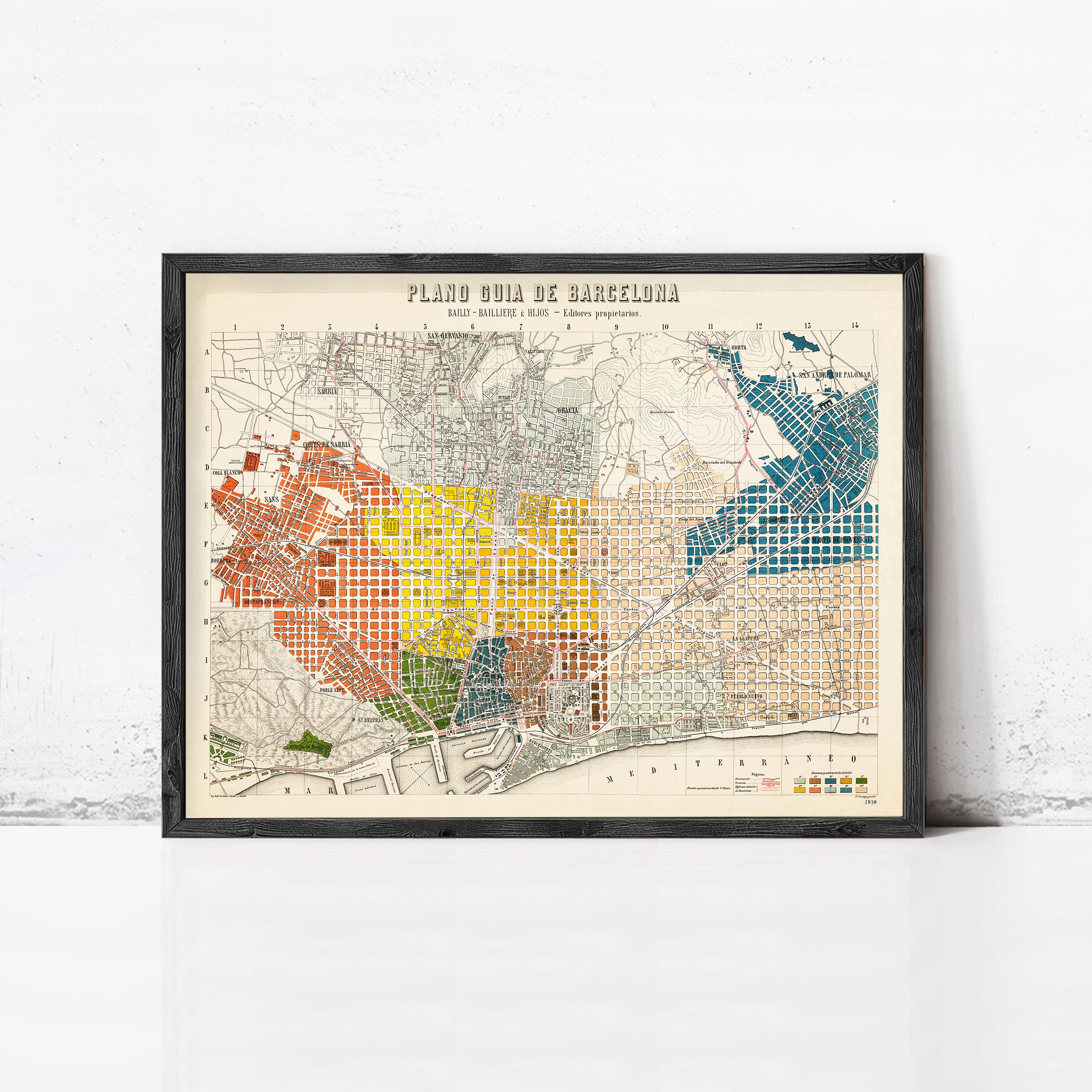 The image is a framed vintage map of Barcelona, Spain, depicting the city's streets and neighborhoods in a colorful and detailed manner.