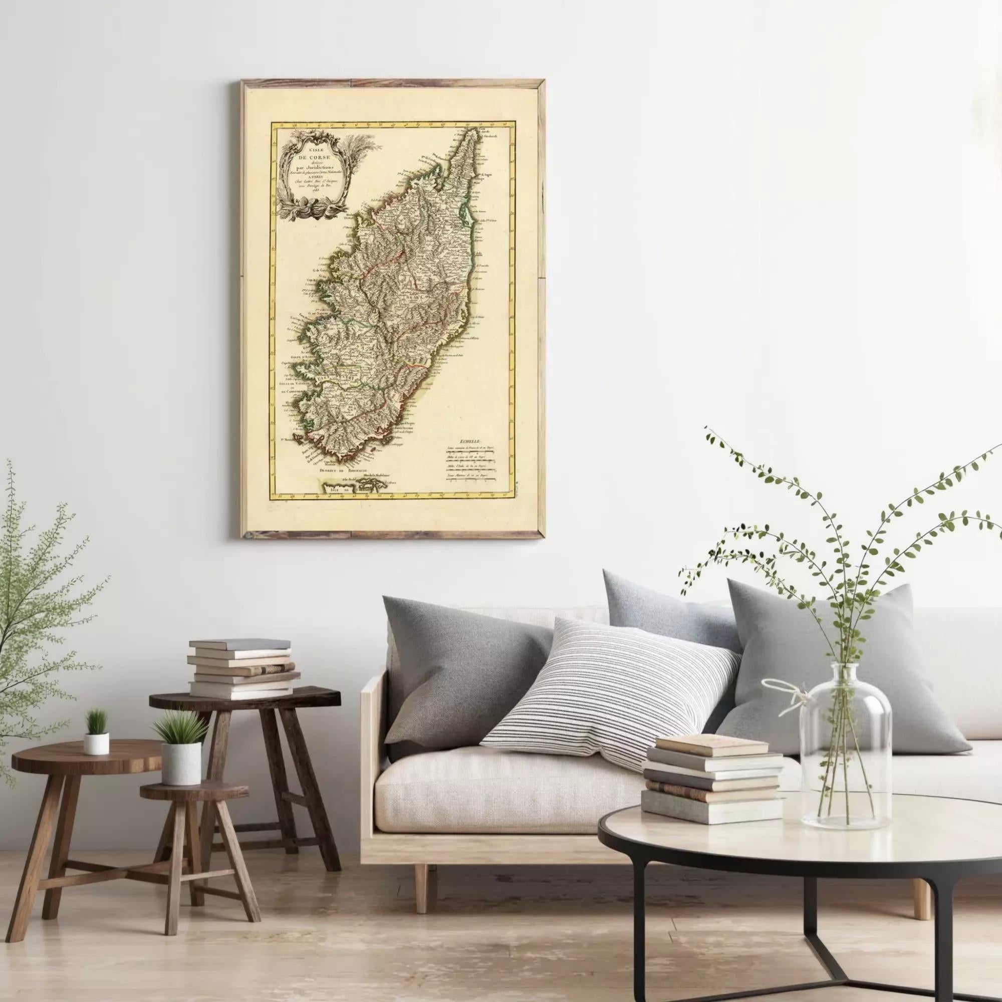 a living room with a large map of Sint Maarten hanging on the wall above a couch with pillows. There are also some books and a vase with greenery on the couch, creating a cozy and inviting atmosphere.