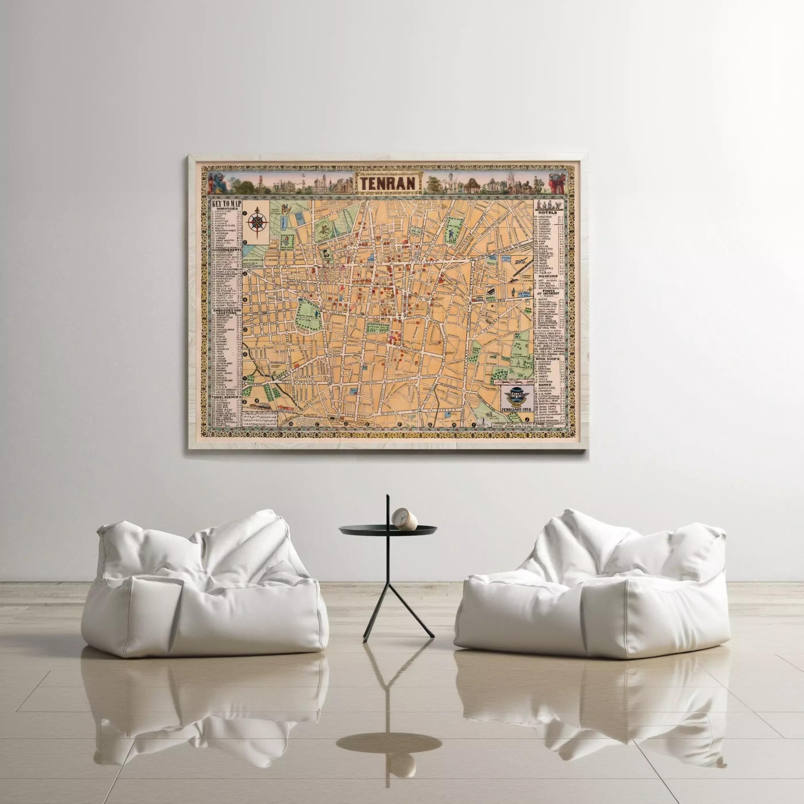 a large map of Tel Aviv, Israel, hanging on a white wall above a pair of white bean bag chairs and a small black table.