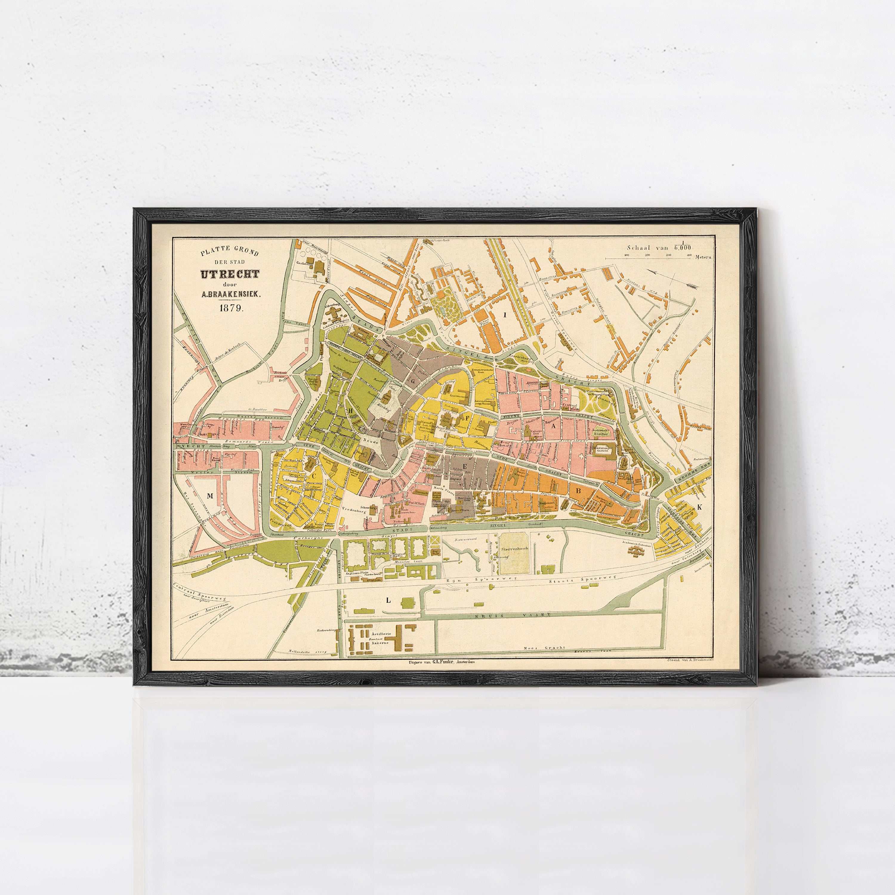 The image is a framed vintage map of a city, likely from the 19th century, depicting the layout and streets of the area.