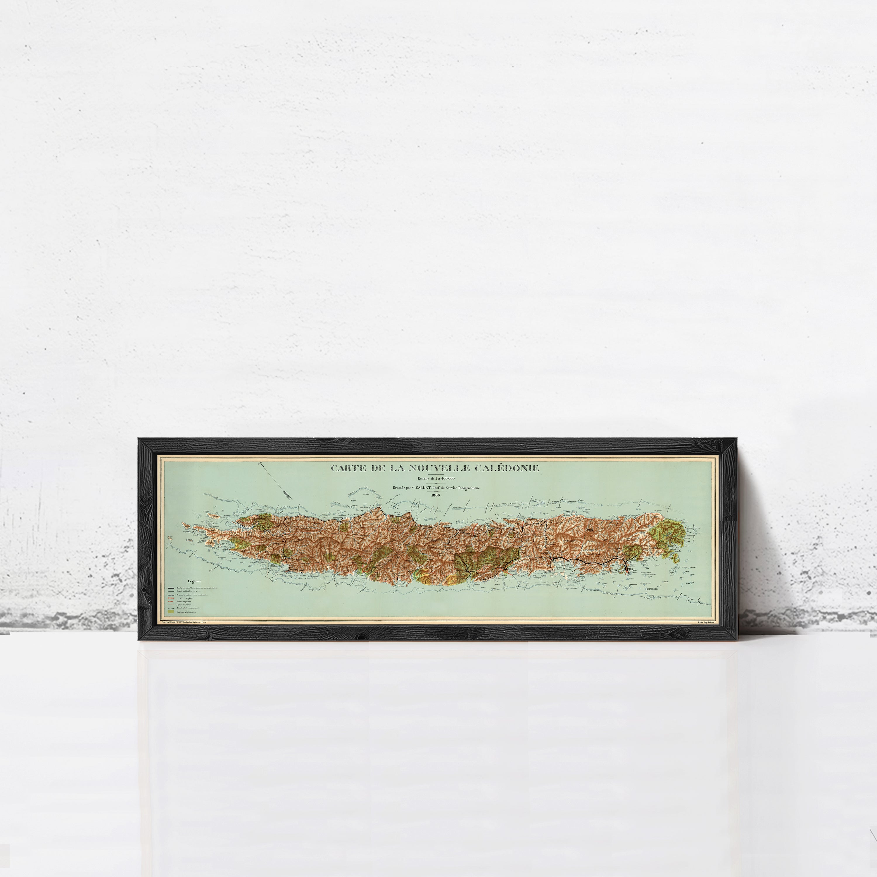 A framed map of the island of La Nouvelle Caledonie, showing the geographical layout and surrounding areas.