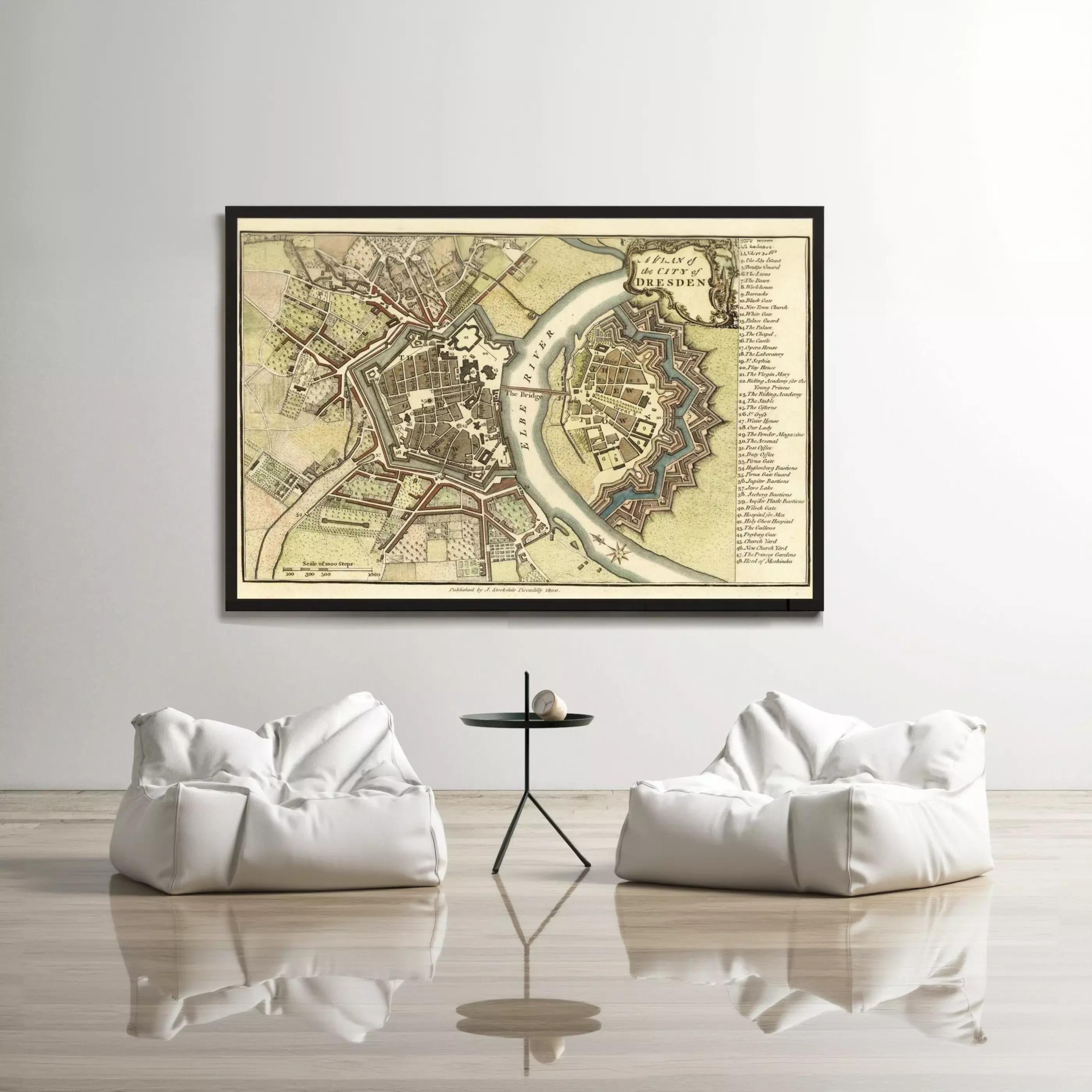 a large framed map of a city hanging on a wall, with two white bean bag chairs positioned in front of it.