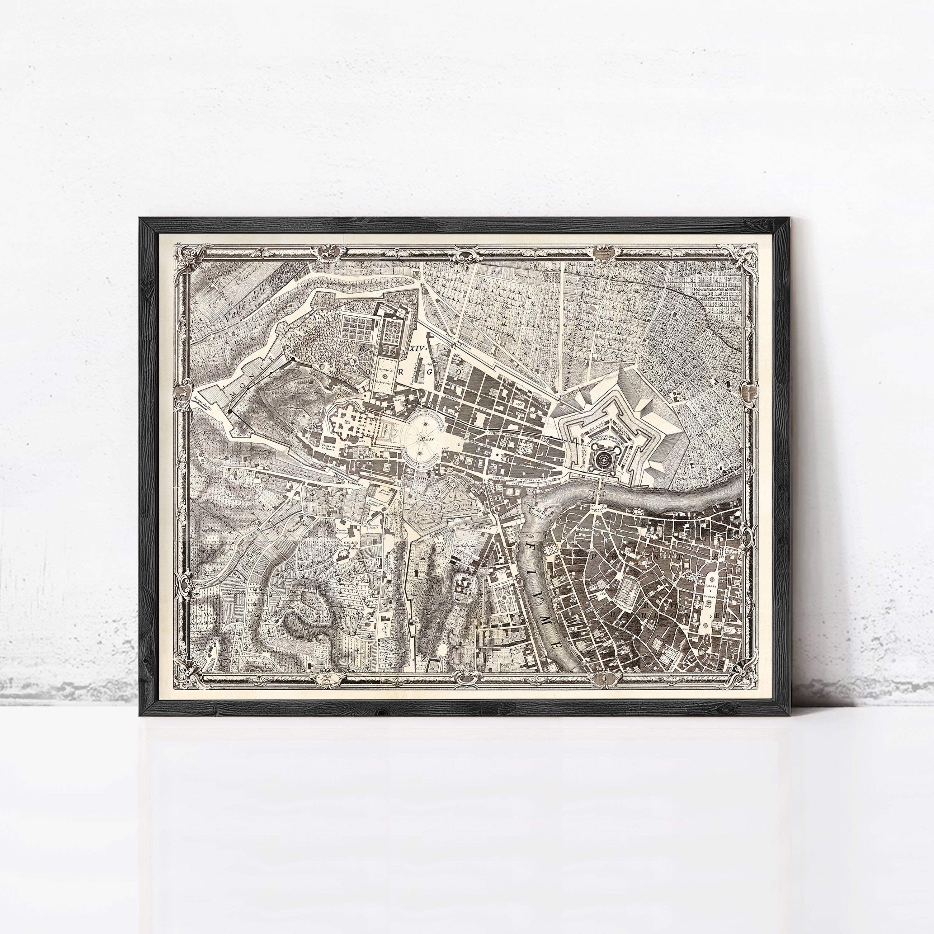 The image is a framed antique map of a city, likely from the 18th century, displayed on a white wall.