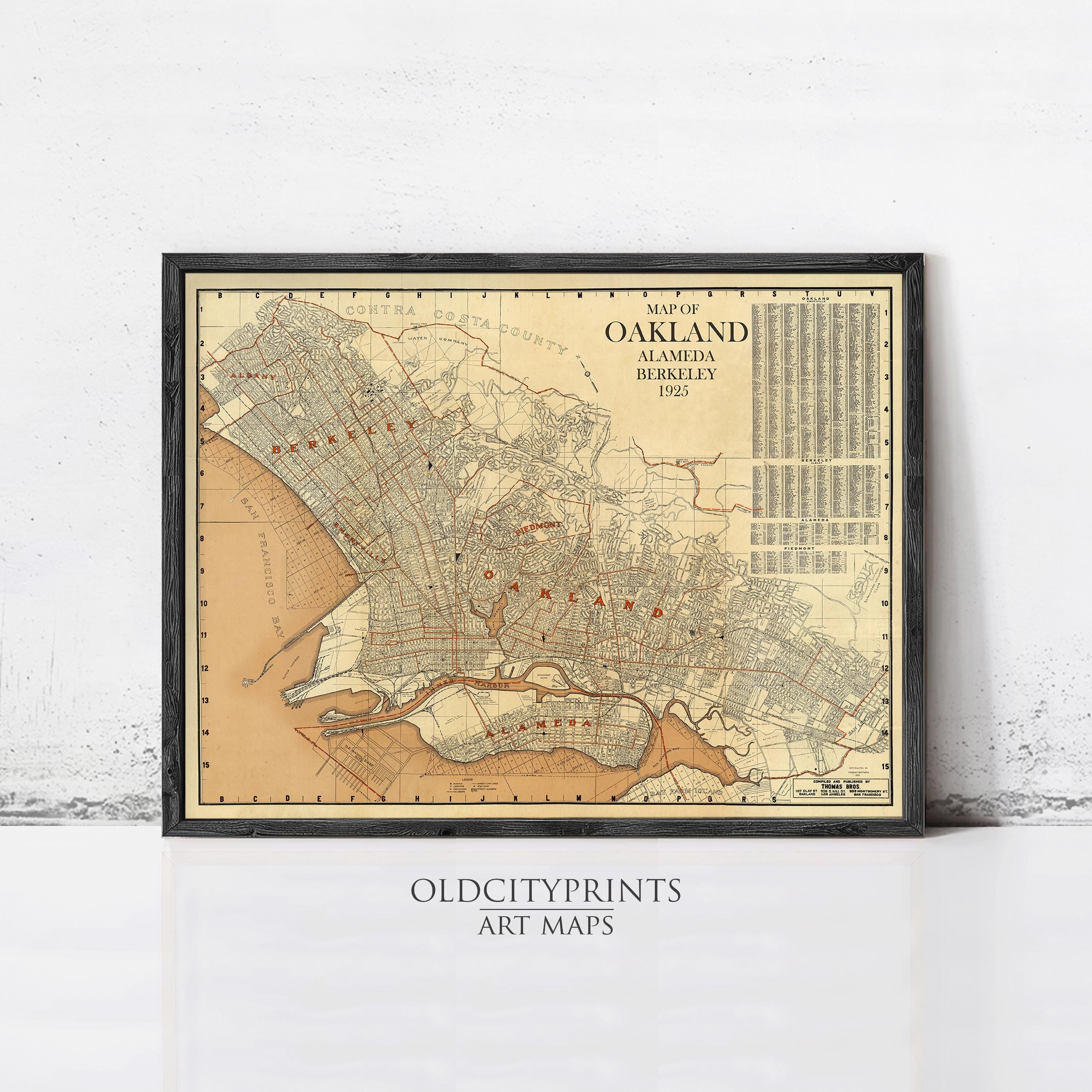 The image is a framed vintage map of Oakland, California, depicting the city's streets and neighborhoods in a detailed and colorful manner.
