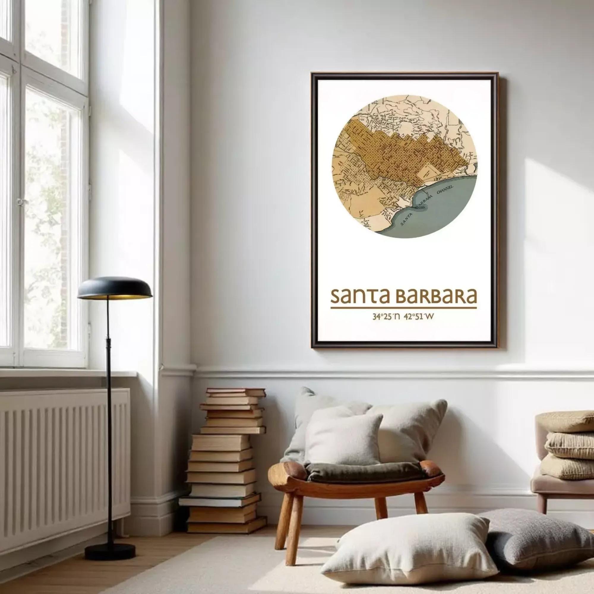 a cozy living room with a large framed map of Santa Barbara, California, hanging on the wall. The room has a comfortable seating area with a wooden chair and a stack of books, as well as a lamp and a window providing natural light.