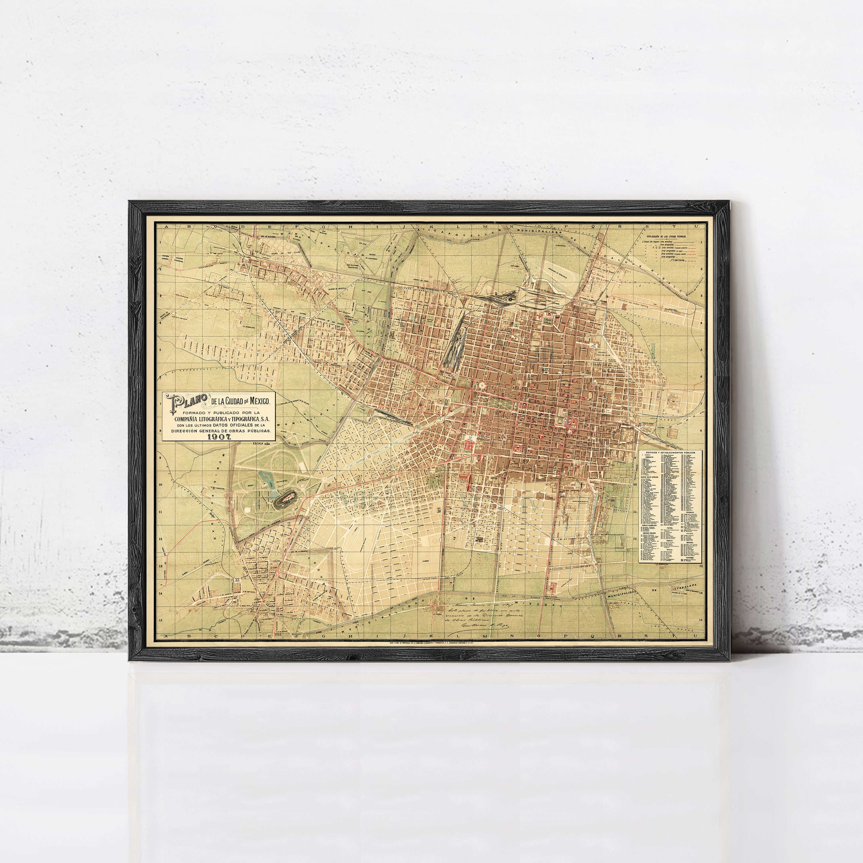 The image is a framed vintage map of a city, likely from the early 20th century, depicting the layout and streets of the area.