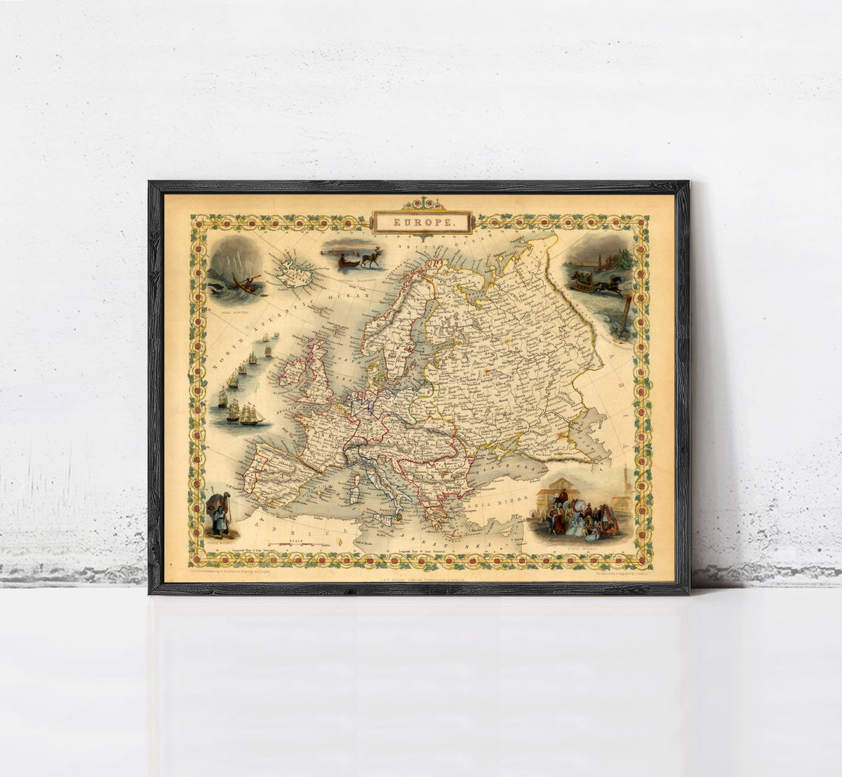 The image is a framed vintage map of Europe, featuring various illustrations and labels.