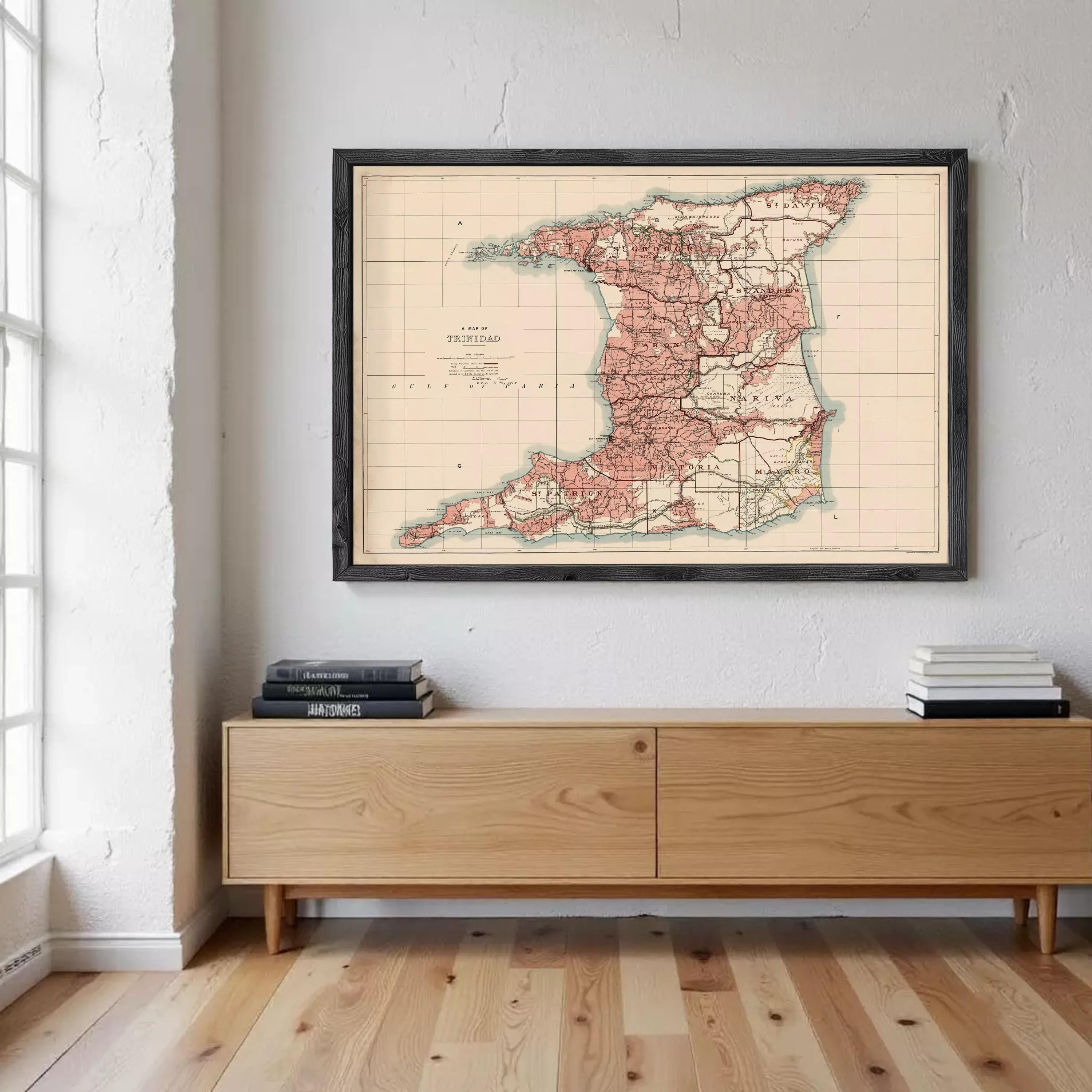 A framed map of Trinidad and Tobago is displayed on the wall above a wooden cabinet or entertainment center.