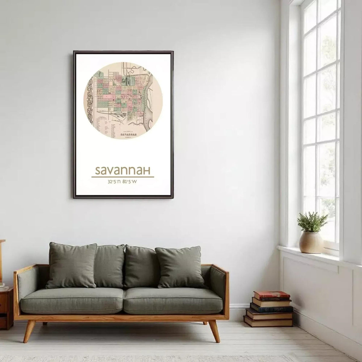 a living room with a gray sofa, a framed map of Savannah hanging on the wall, and a window with a plant on the sill.