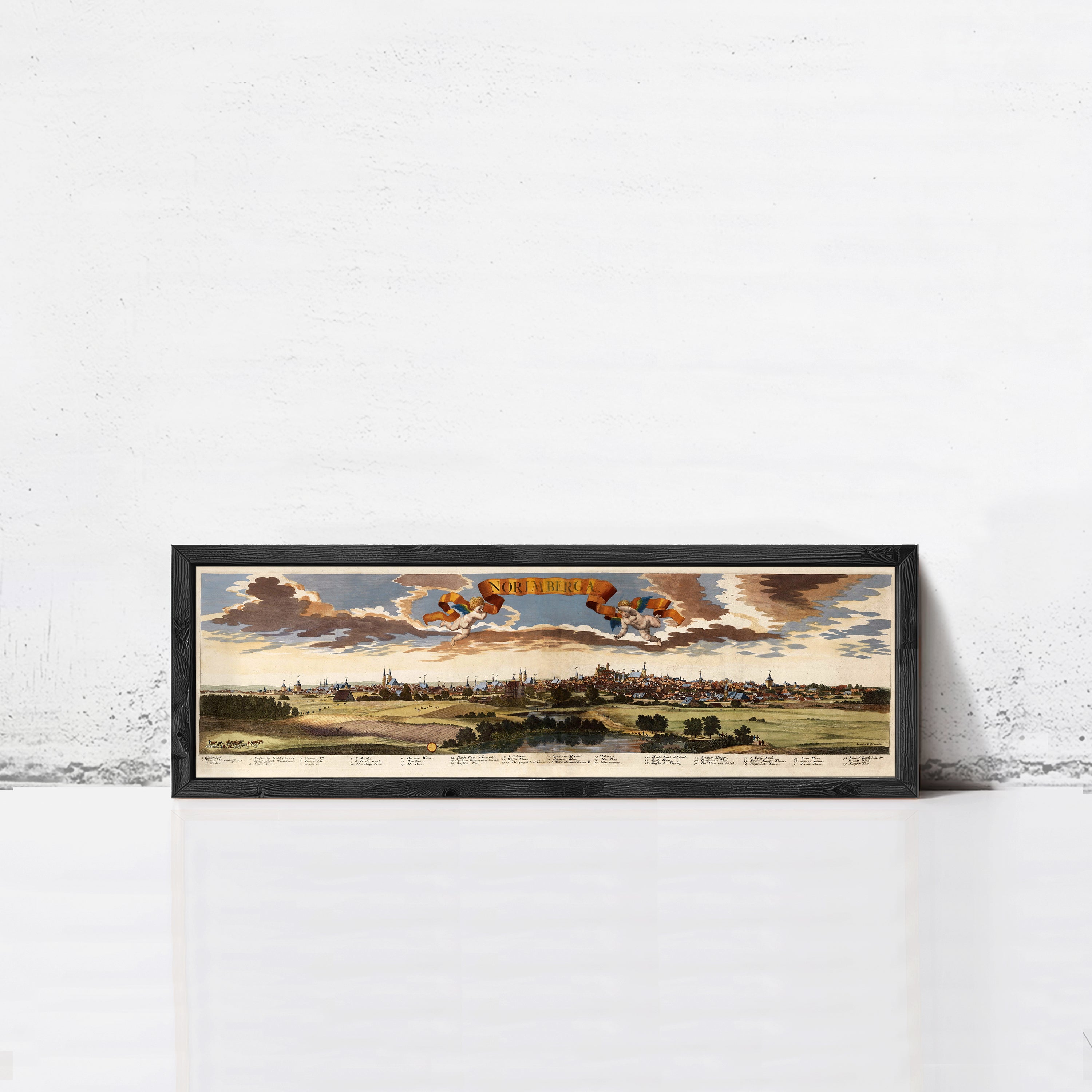A framed painting depicting a cityscape with a cloudy sky in the background.