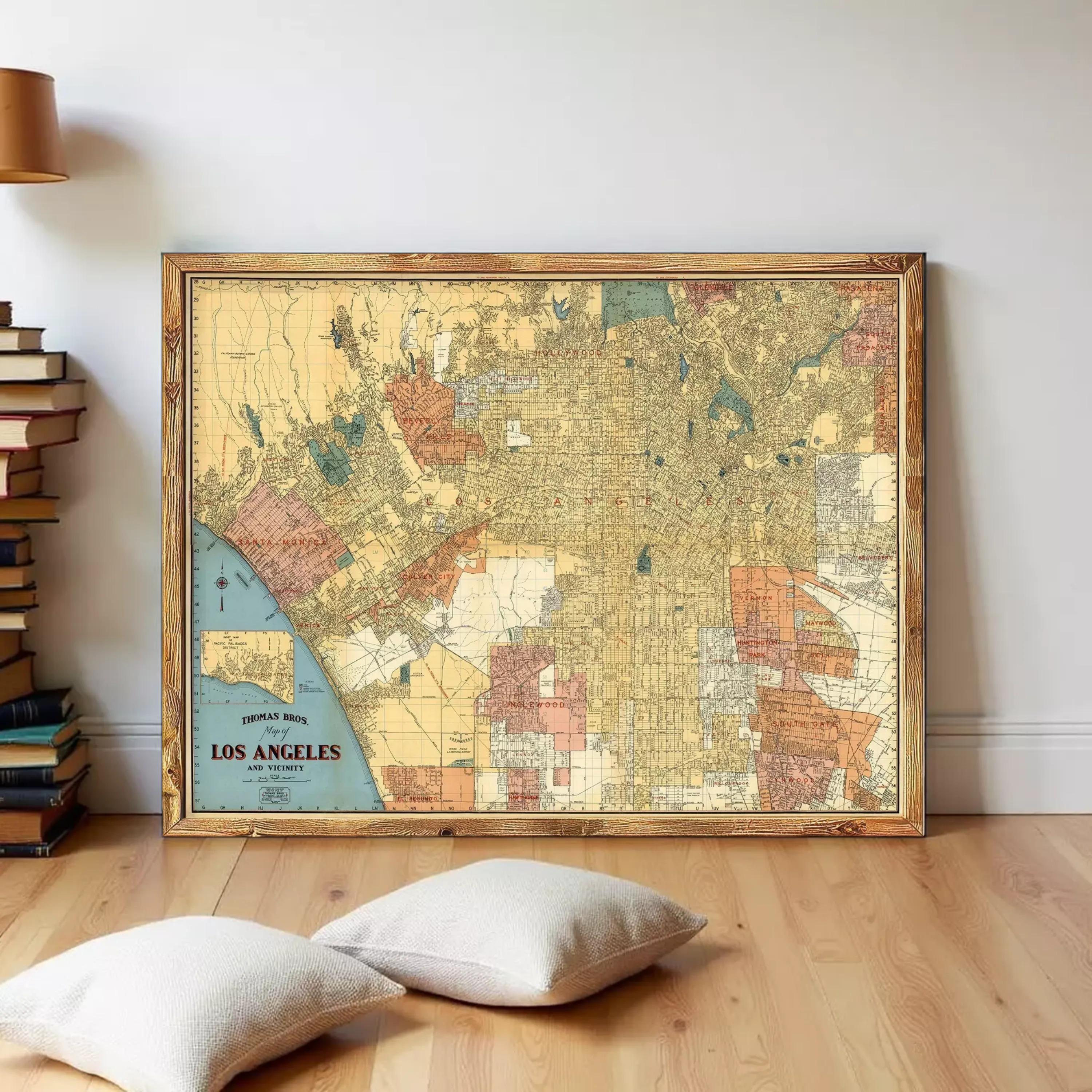 A framed vintage map of Los Angeles, California, with a wooden frame and a light wood floor in the foreground.