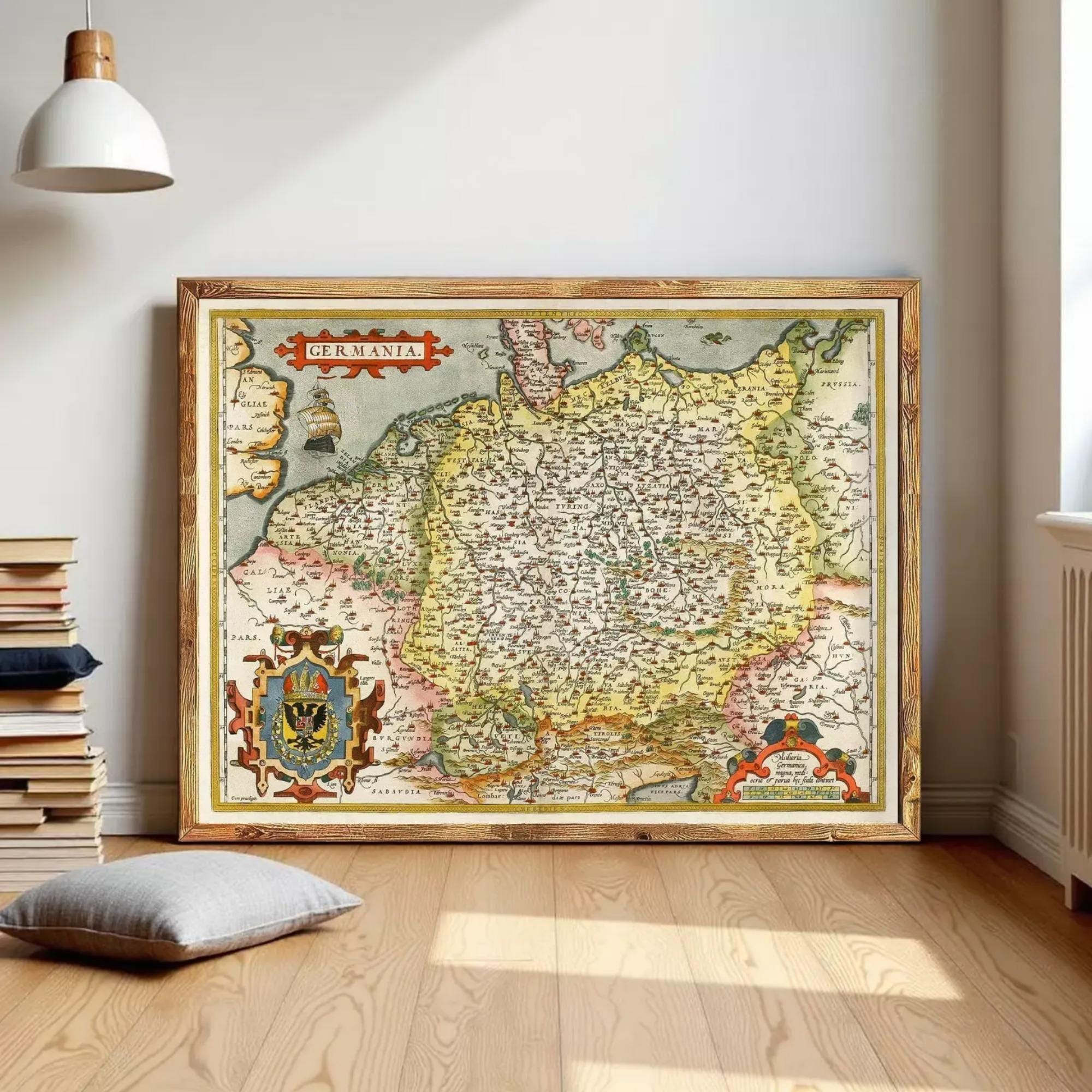 a large, framed map of Germany, with a wooden floor and a stack of books in the background.