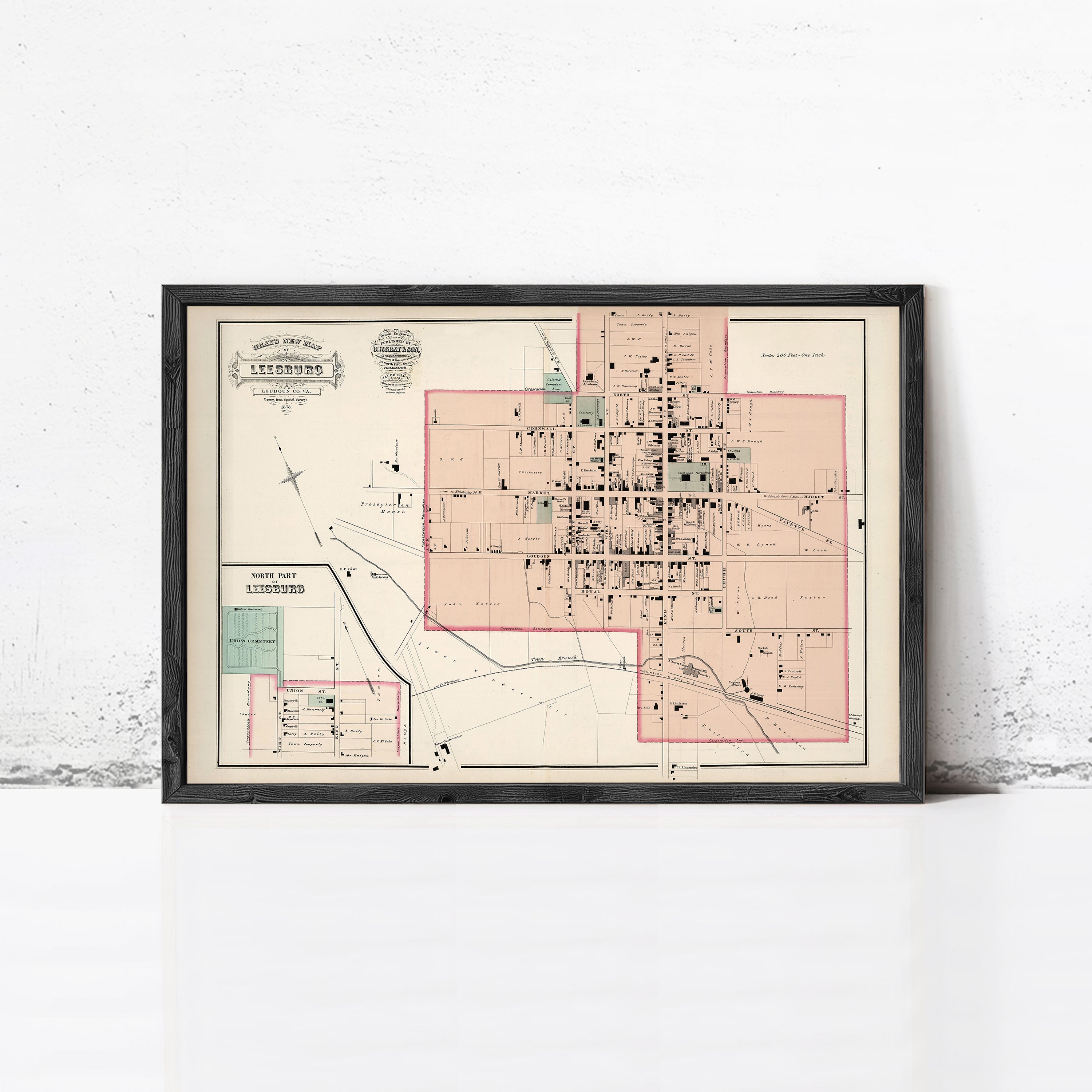The image is a framed map of a city, likely from the early 20th century, depicting the layout and streets of the area.