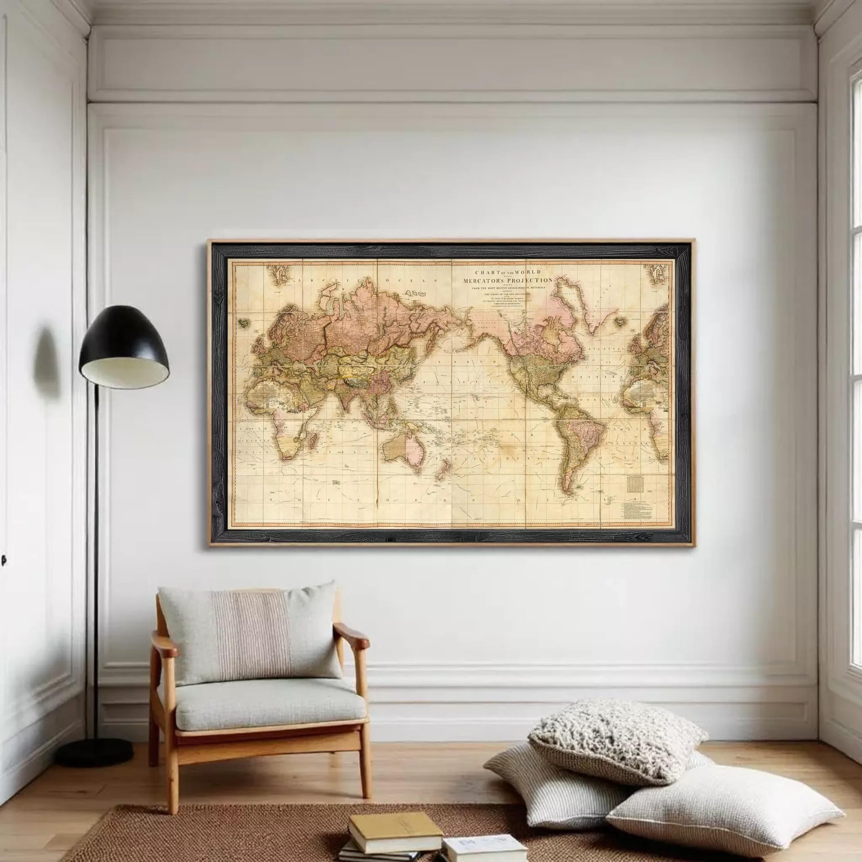 The image is a framed vintage world map with a black border, displayed on a white wall.