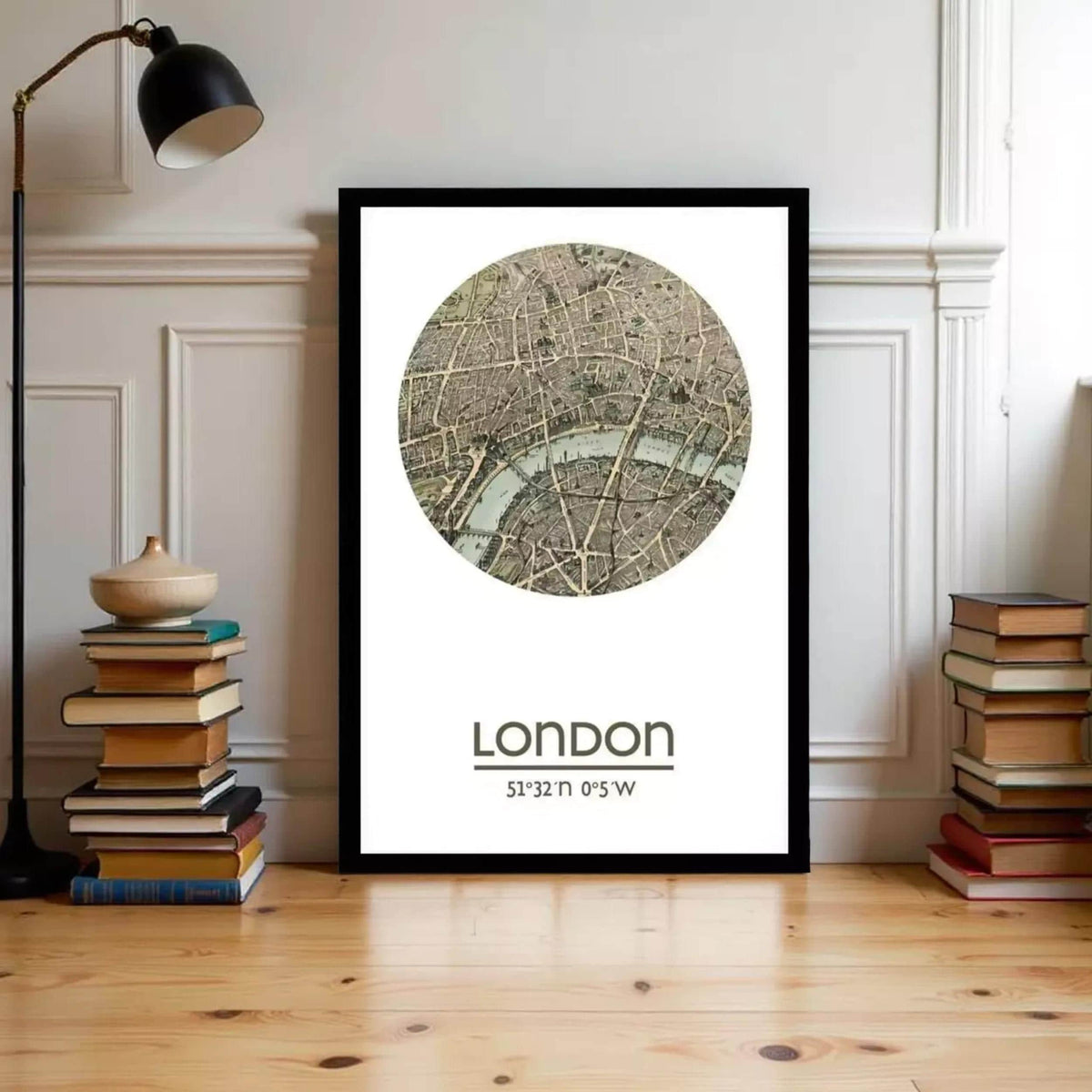 A framed map of London with a circular design on the front, placed on a wooden floor next to a stack of books.
