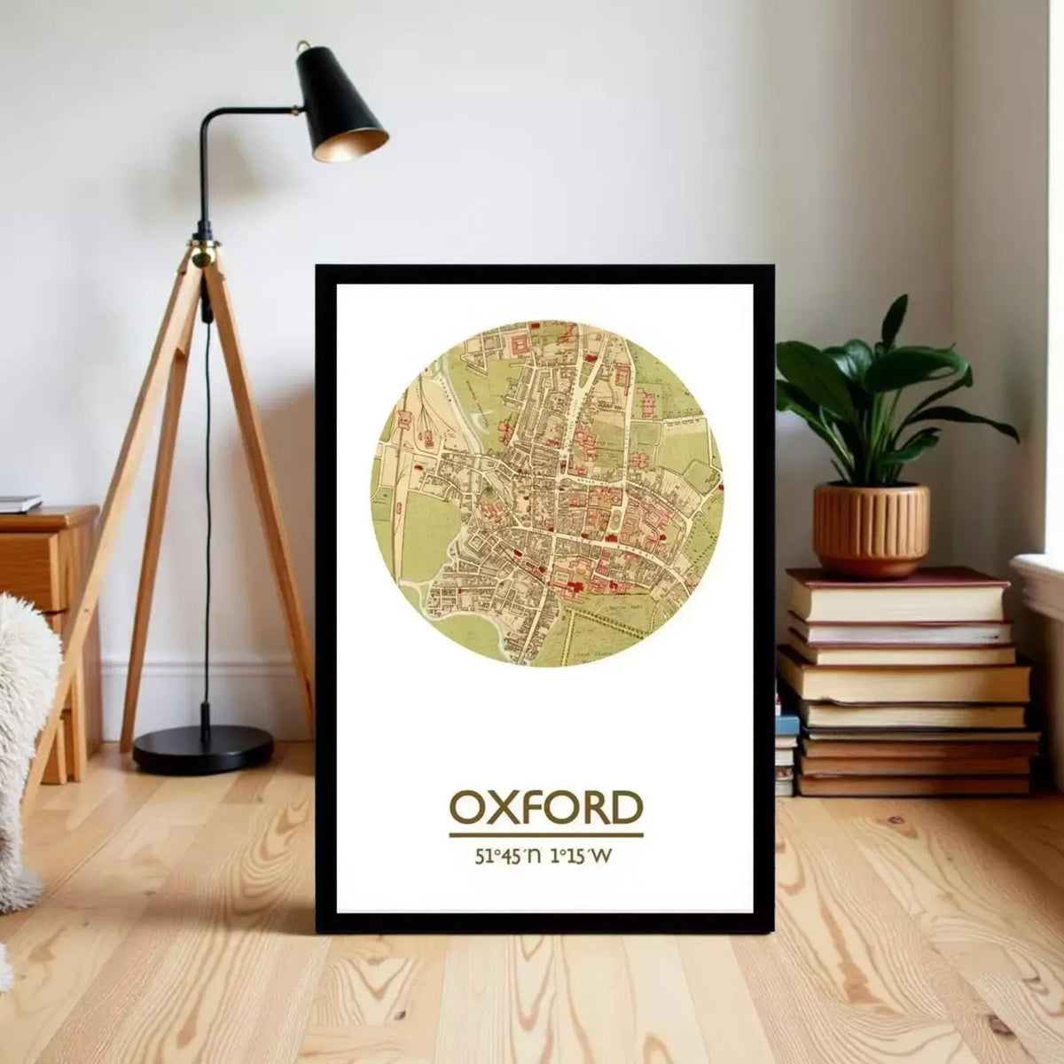 A framed map of Oxford, UK, with a lamp and books in the background.