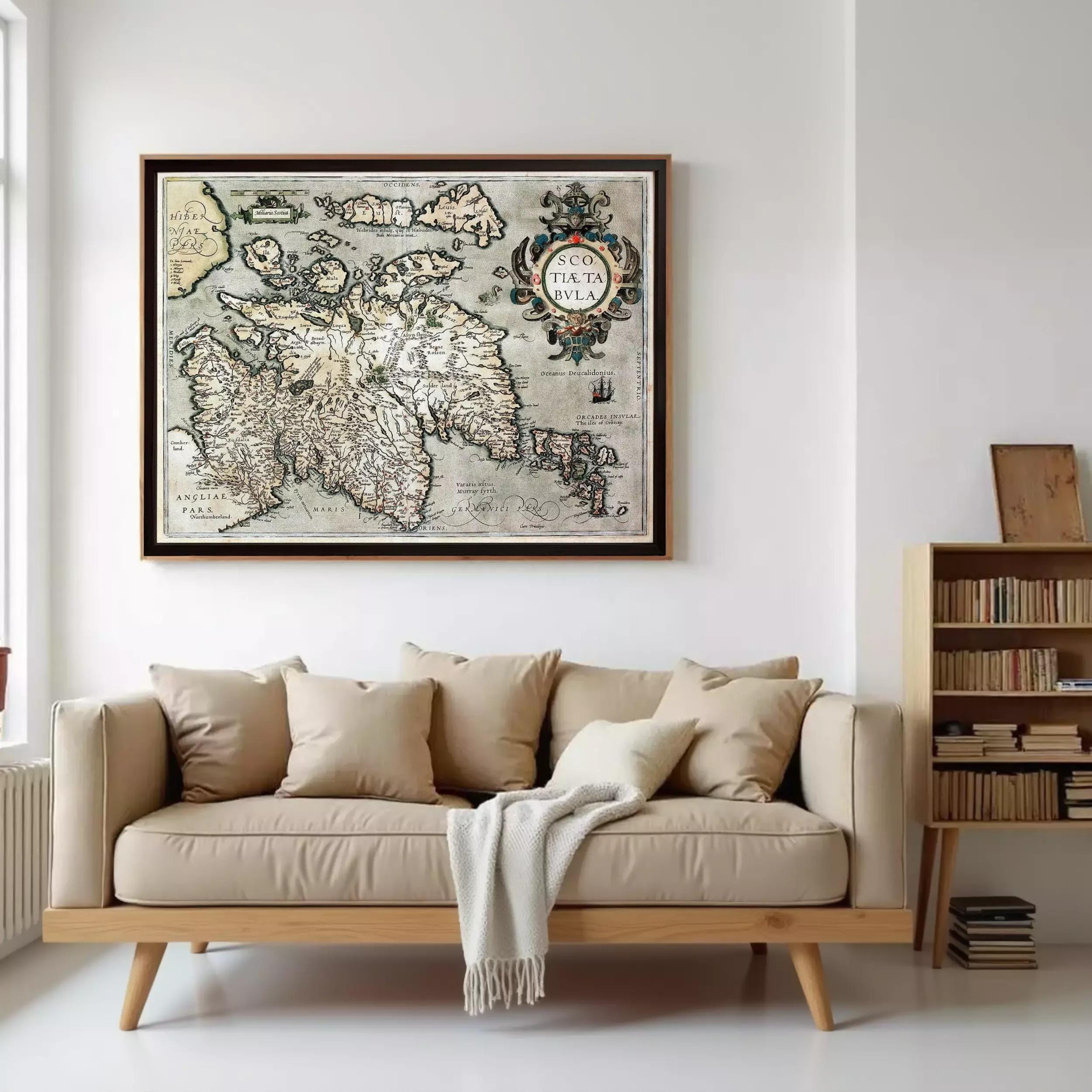 a large framed map of Iceland hanging on a wall above a beige sofa with a white throw blanket draped over it.