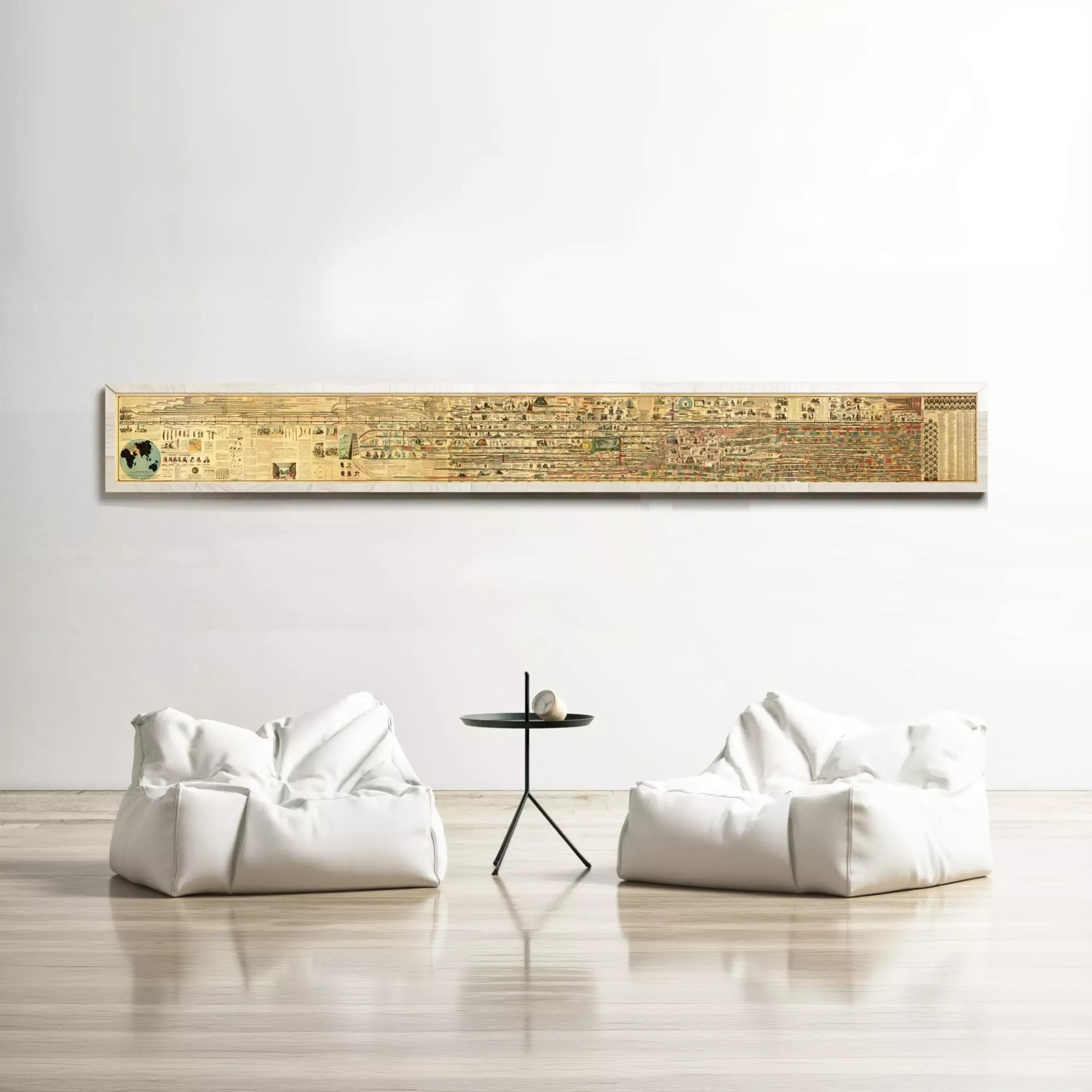 a minimalist living room setting with a large, long, horizontal painting hanging on the wall above two white bean bag chairs and a small black table.