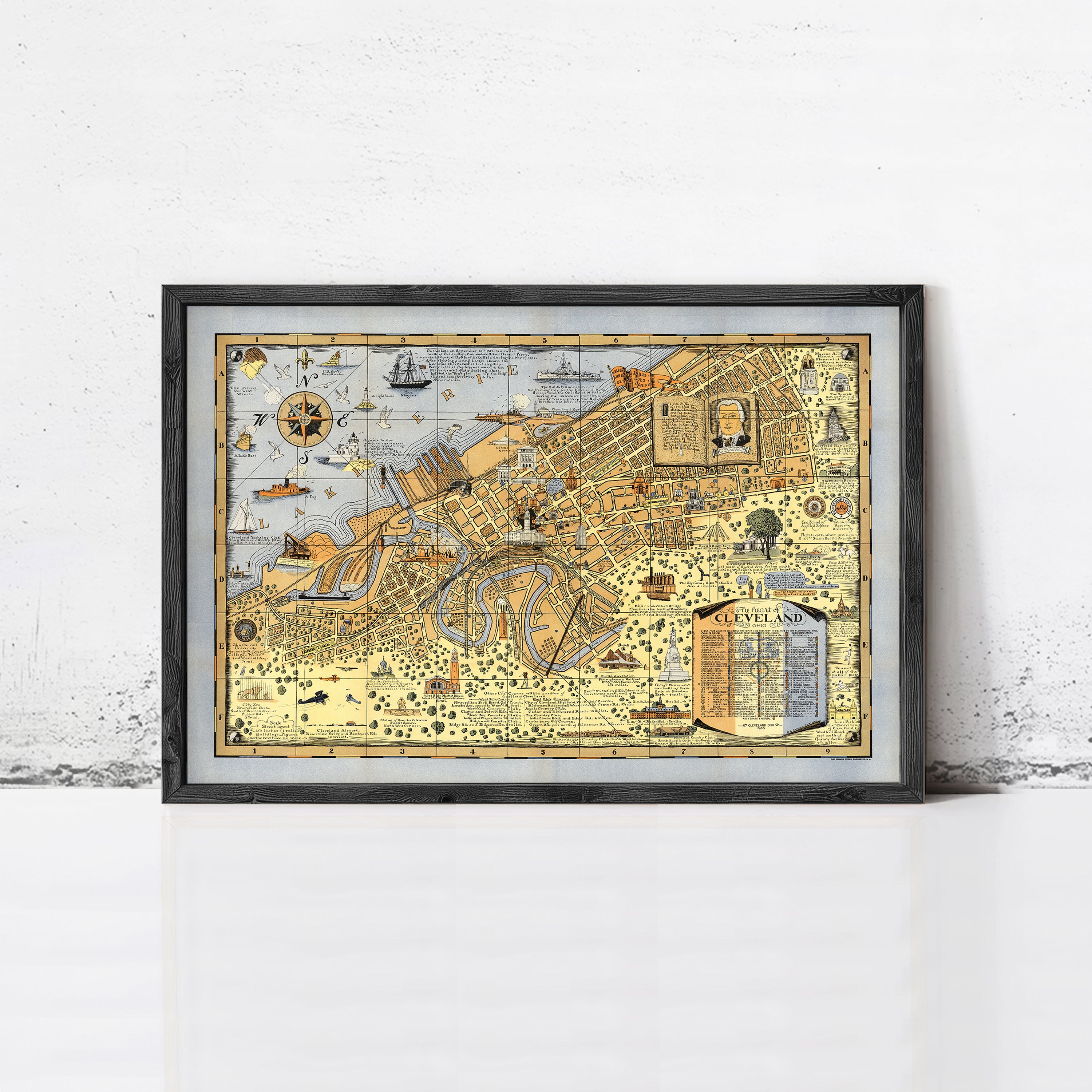 The image is a framed vintage map of Cleveland, Ohio, depicting various landmarks and locations within the city.