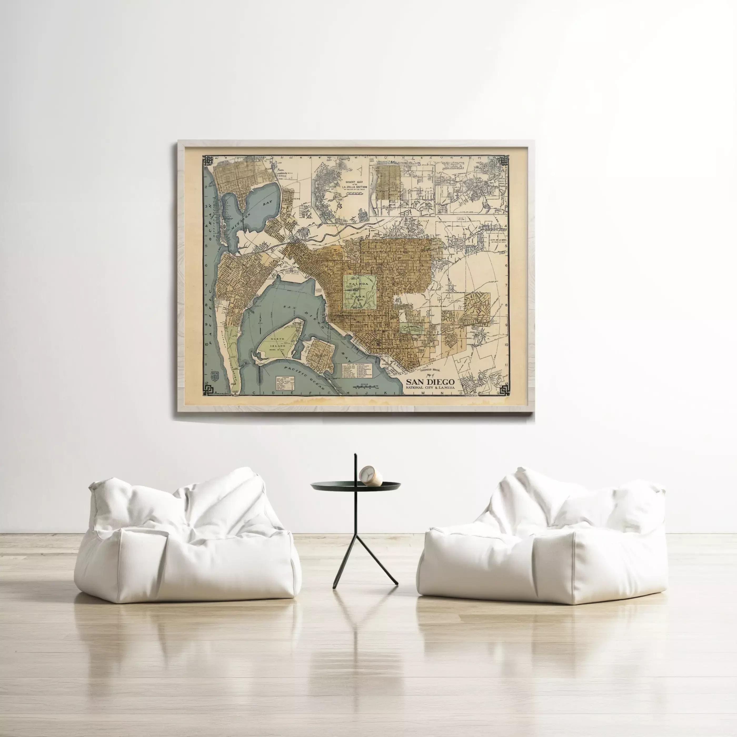a large framed map of San Diego hanging on a white wall, with two white bean bag chairs positioned in front of it.
