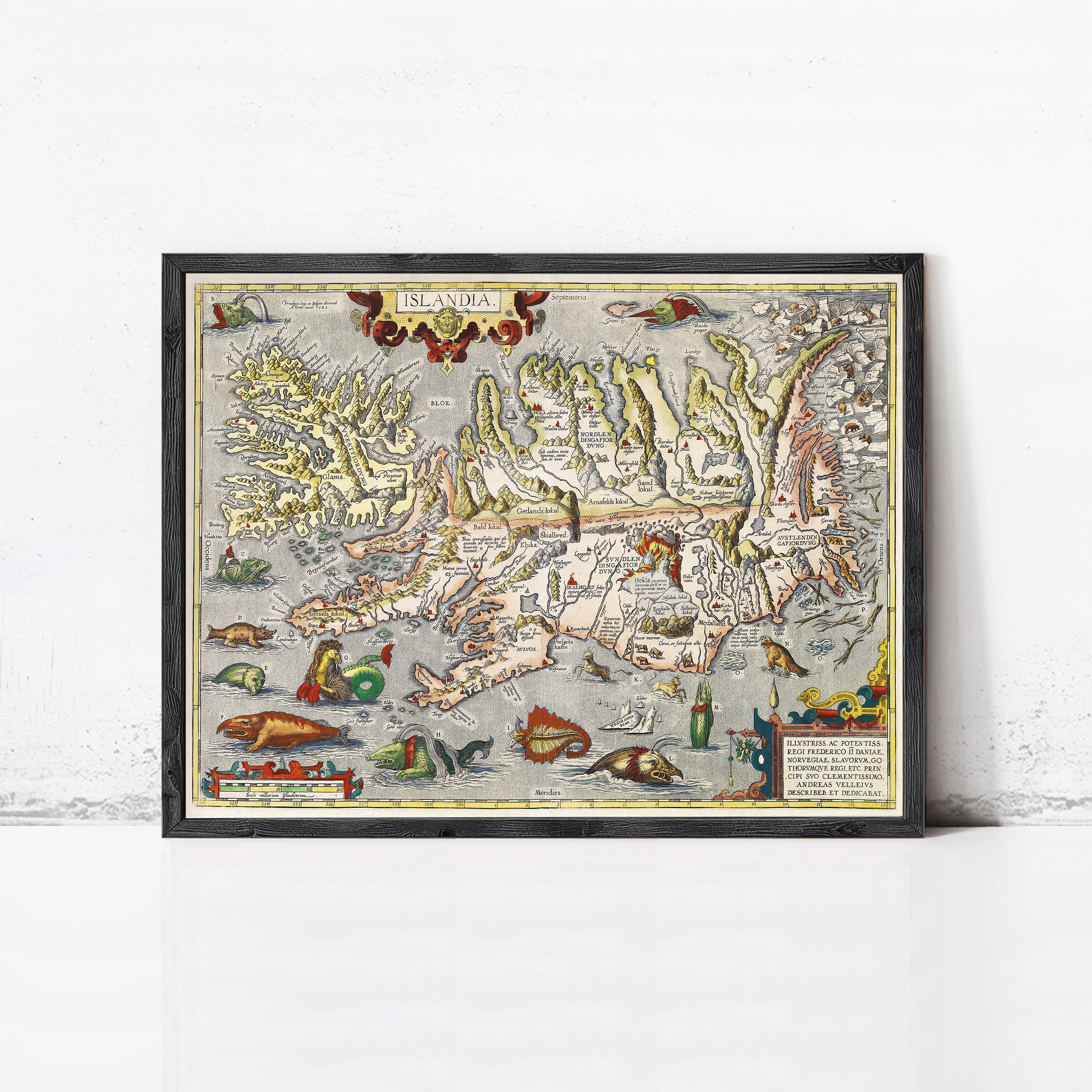 The image is a framed vintage map of Iceland, featuring intricate illustrations and detailed geographical information.