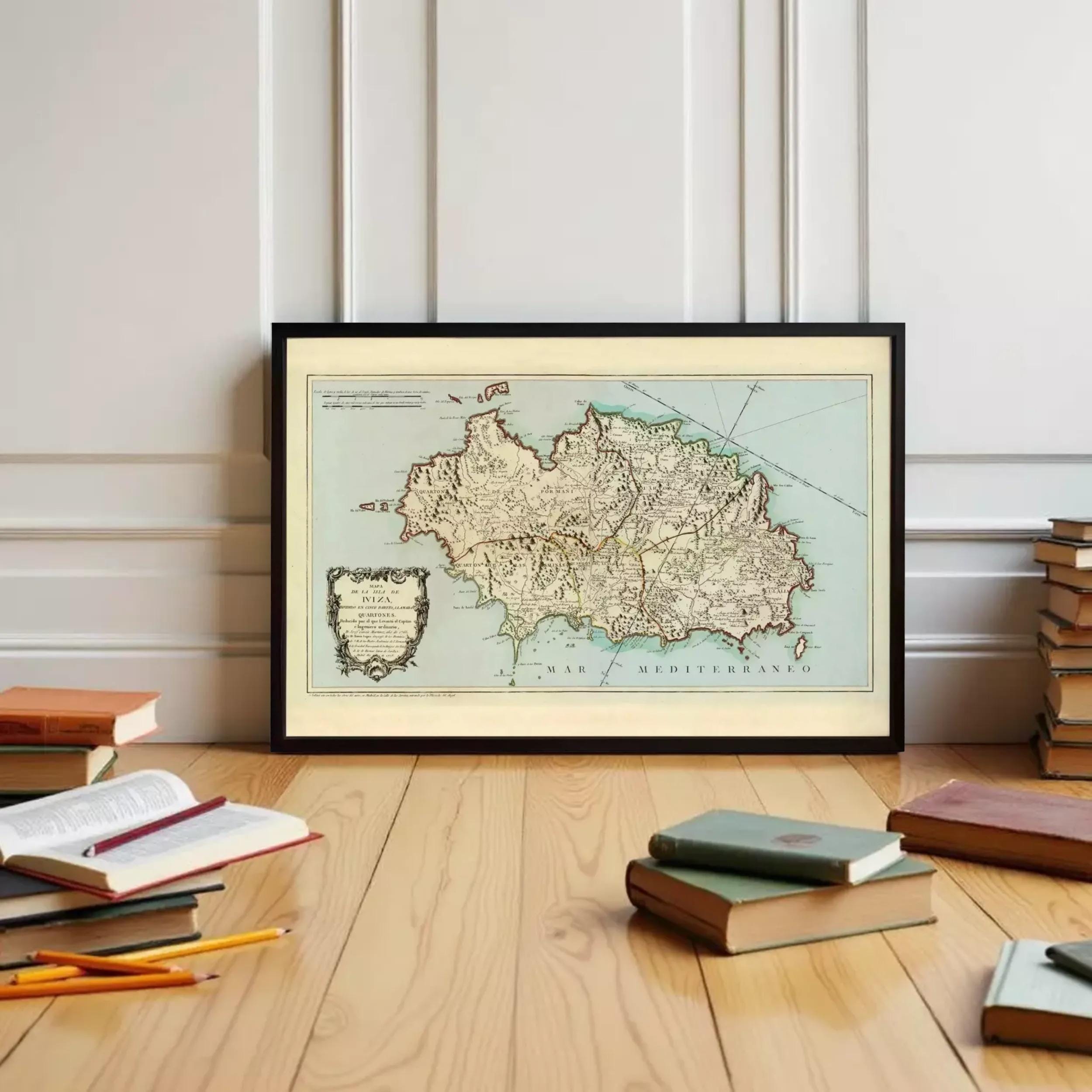 A framed map of the Mediterranean region is displayed on a wooden floor, surrounded by various books and stationery items.