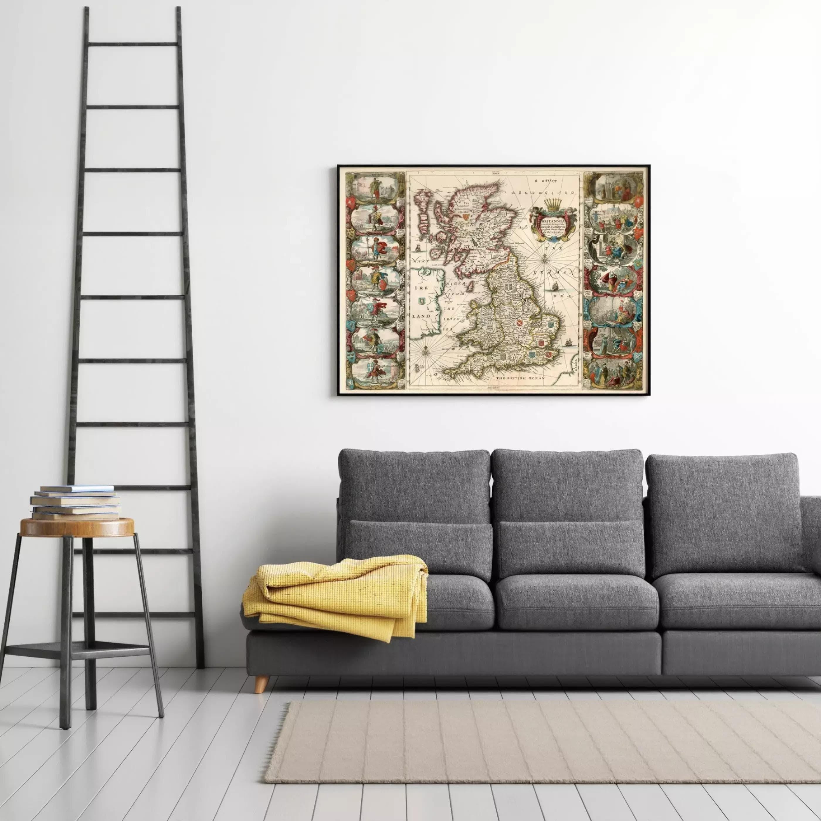 a gray sofa with a yellow blanket draped over it, and a framed map of the United Kingdom hanging on the wall above the sofa.