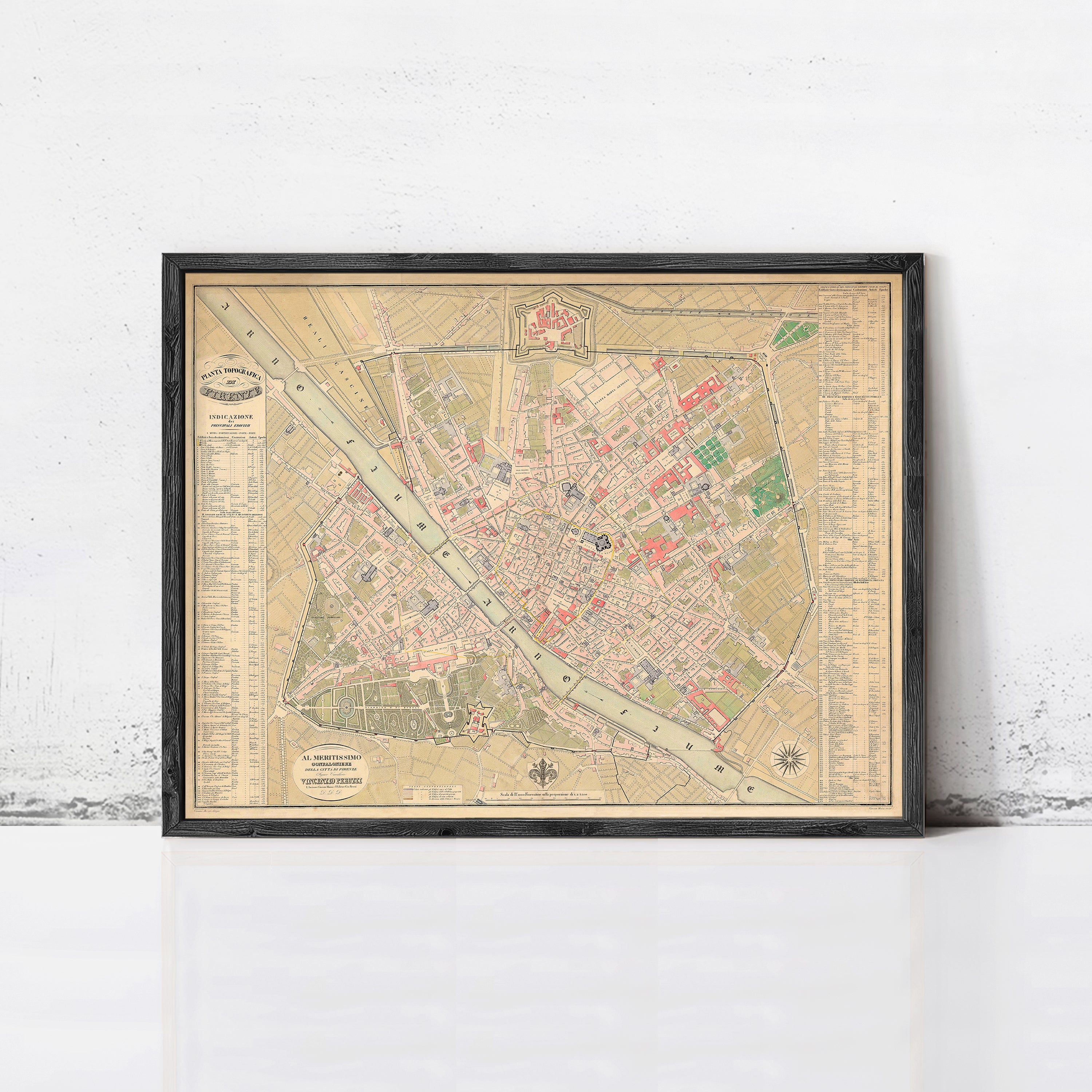 The image is a framed vintage map of a city, likely from the 19th century, displayed on a white wall.