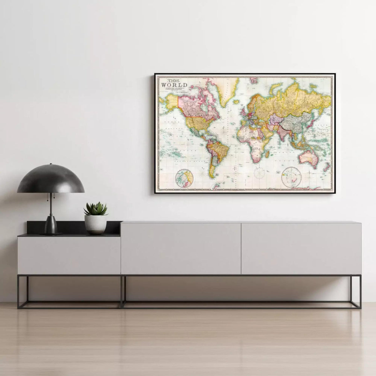 a large world map hanging on a wall above a gray console table with three drawers.