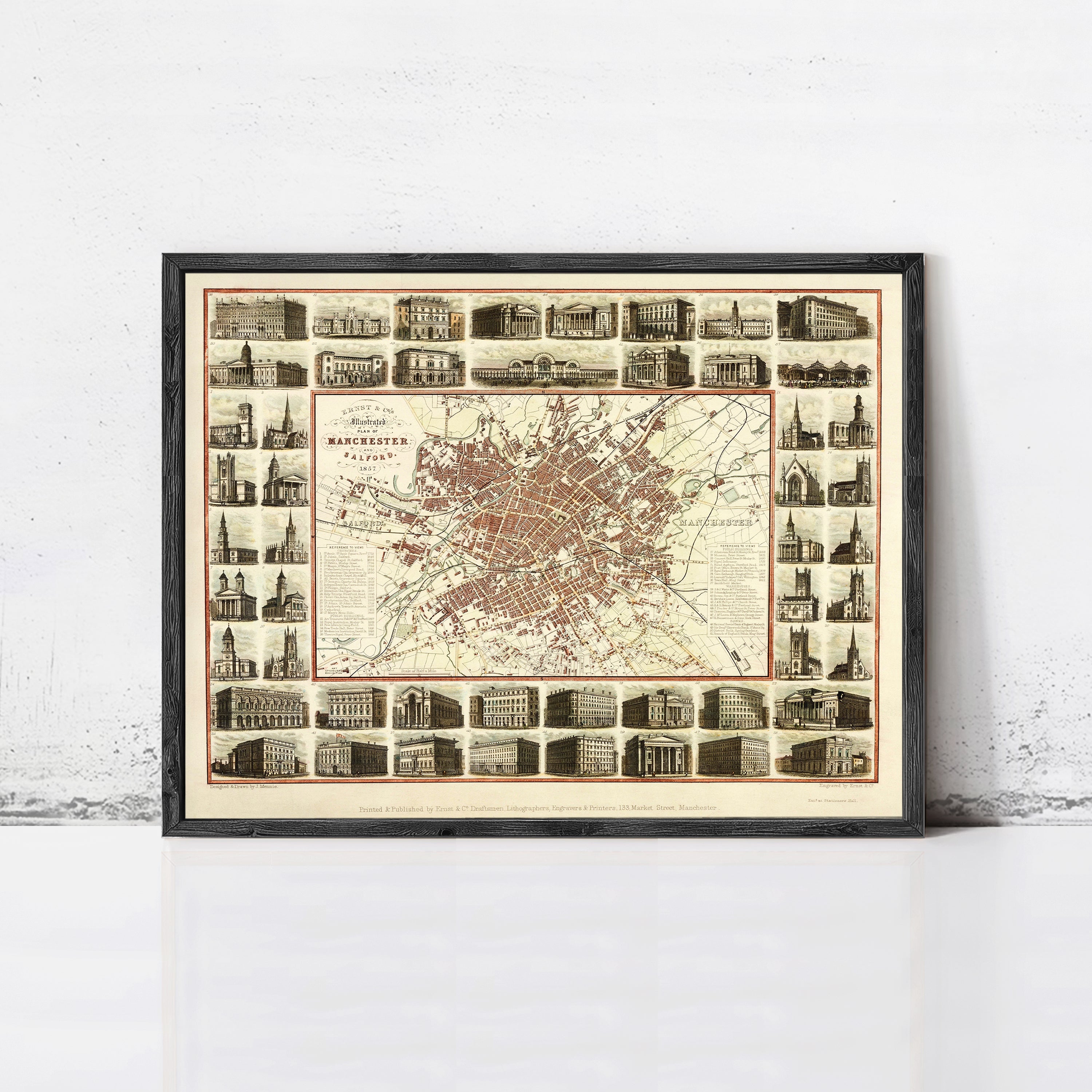 The image is a framed vintage map of Manchester, London, England, depicting various buildings and landmarks within the city.