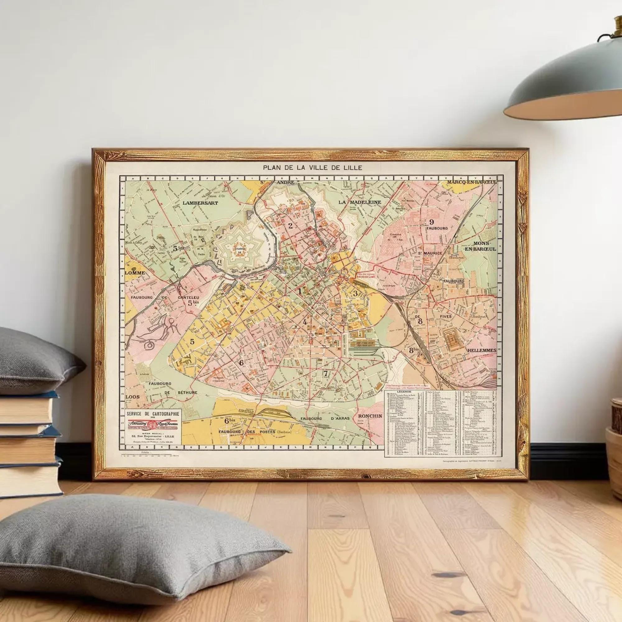 a large framed map of a city, with a wooden floor and a lamp in the background.