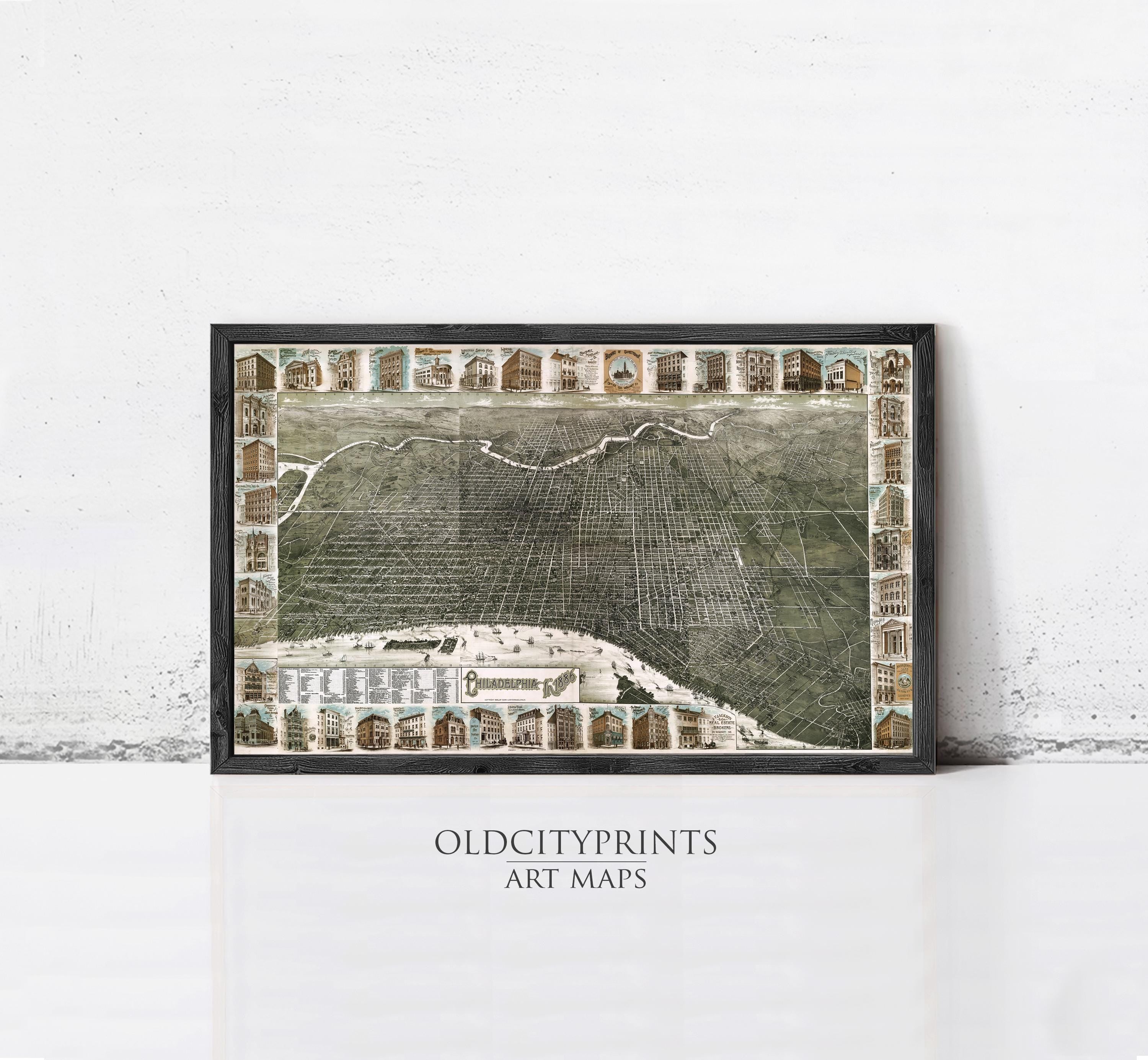 The image is a framed art print depicting a detailed map of a city, with various buildings and landmarks represented in a collage-like manner.