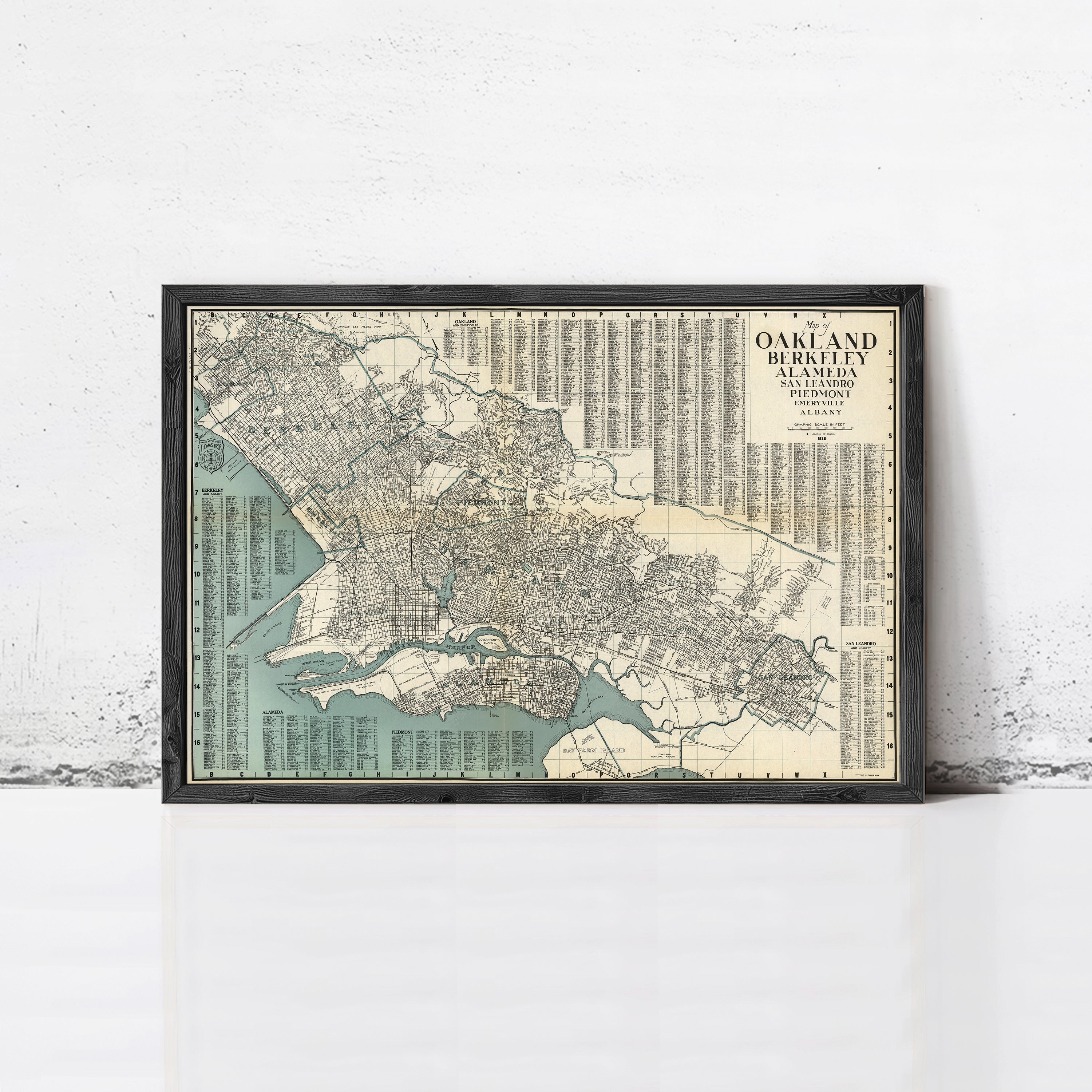 The image is a framed vintage map of Oakland, California, with a detailed layout of the city's streets, neighborhoods, and landmarks.