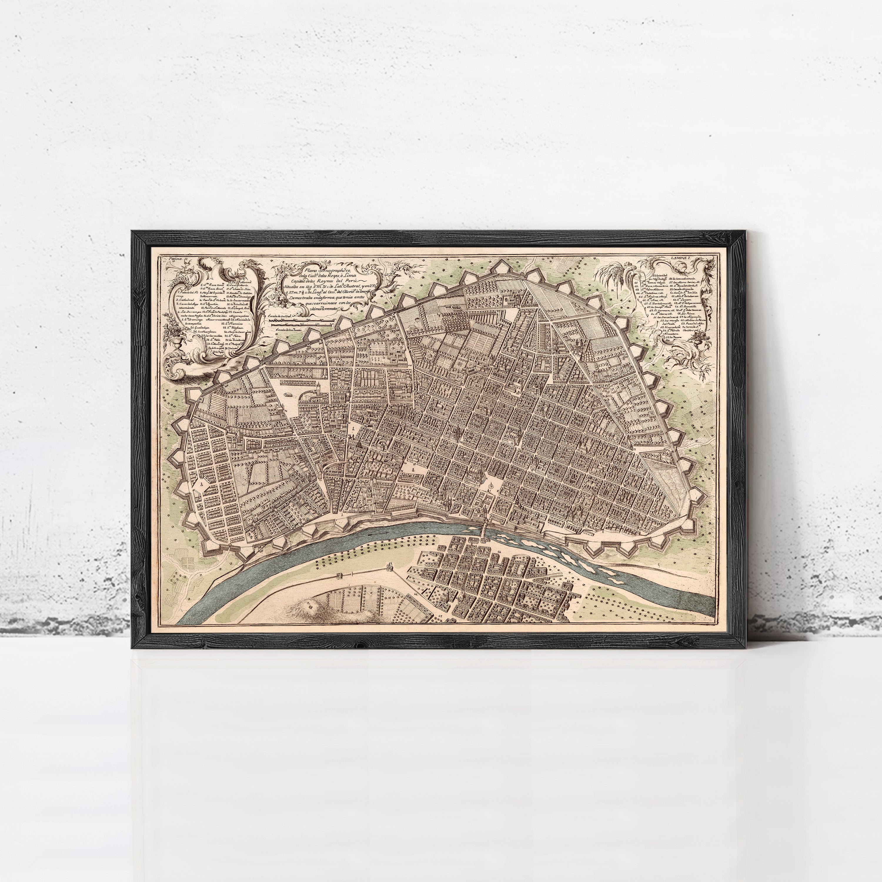 The image is a framed antique map of a city, depicting a detailed layout of the streets, buildings, and other urban features.