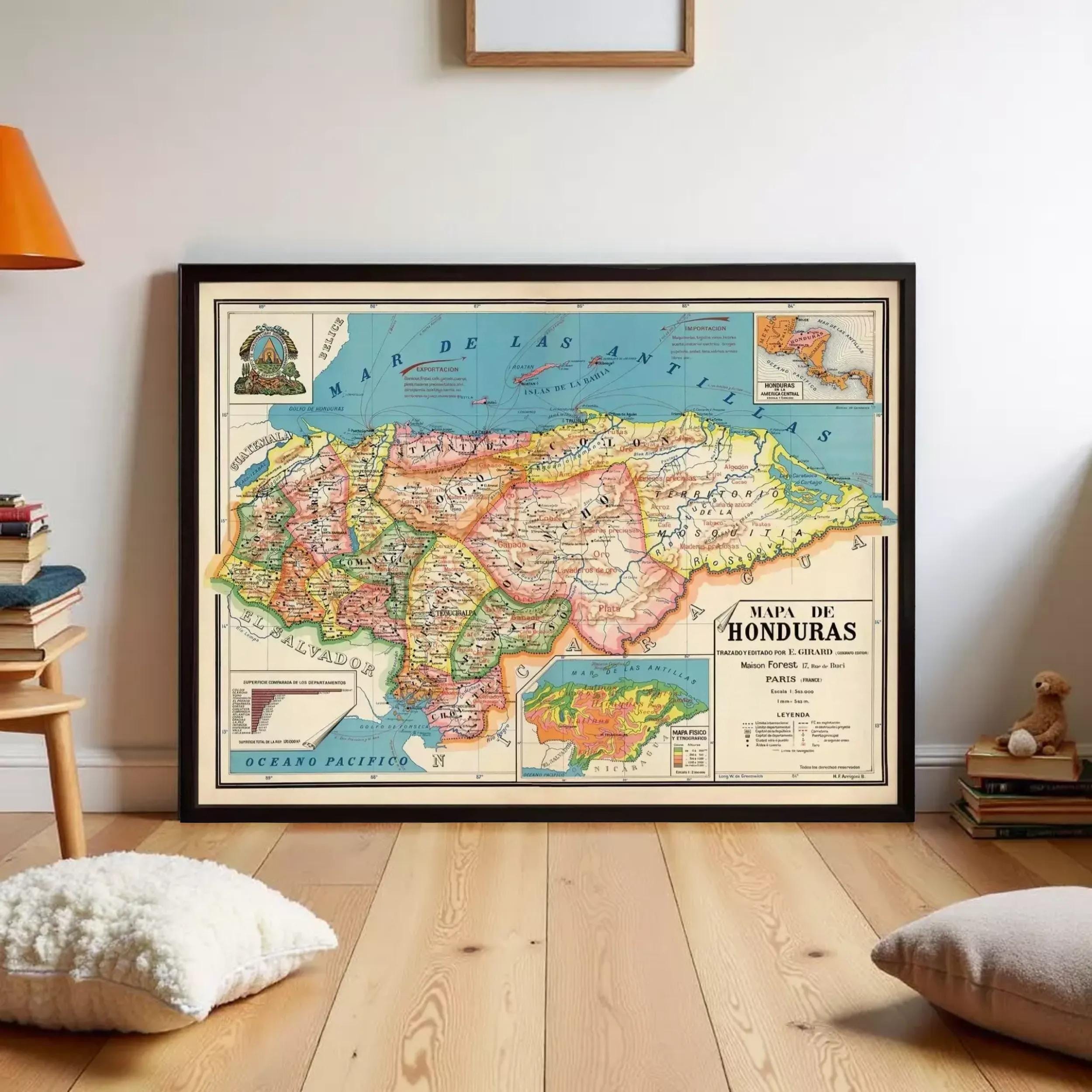 a framed map of Honduras, with a wooden floor and a few books and pillows in the background.