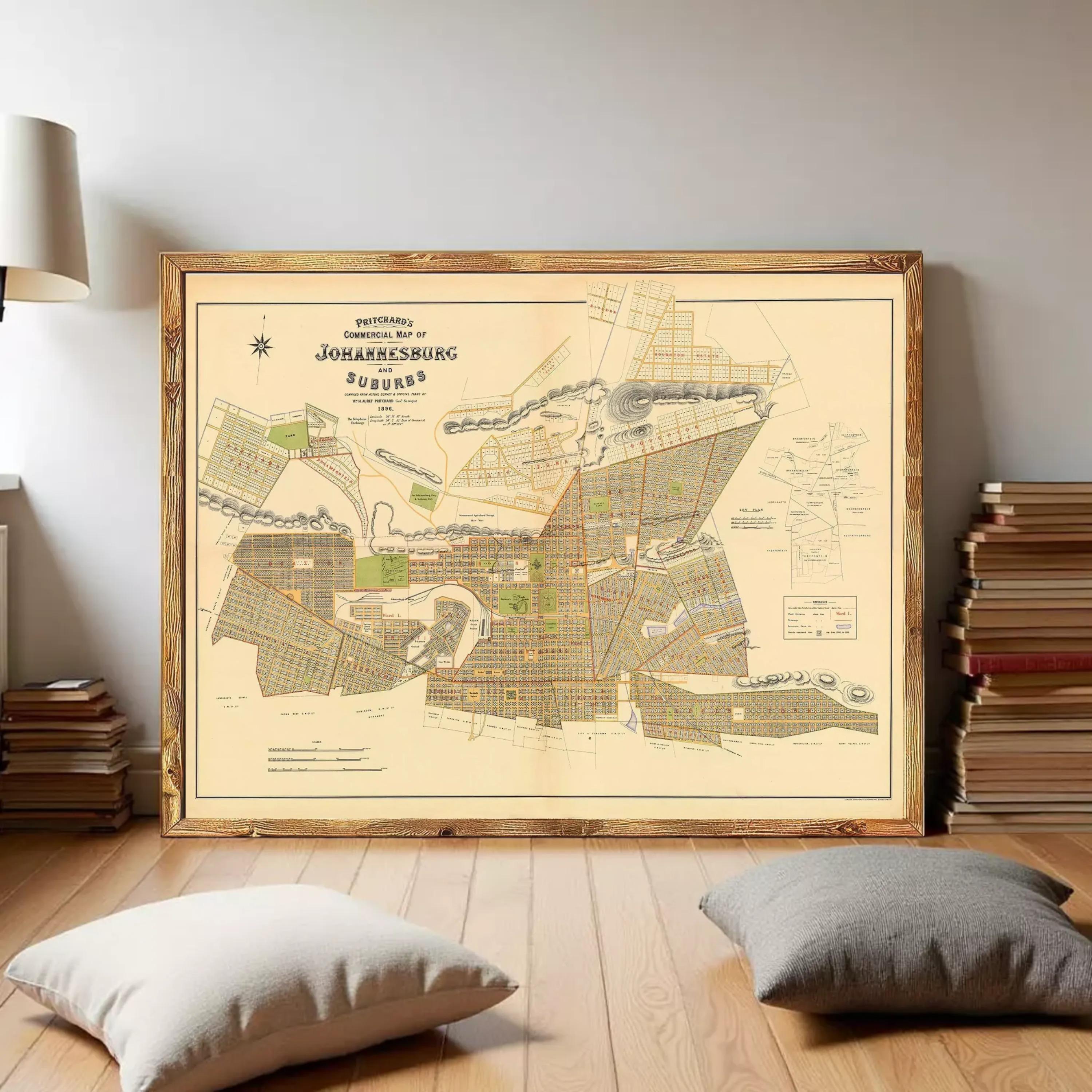 a large framed map of Johannesburg, South Africa, with a wooden floor and a stack of books in the background.