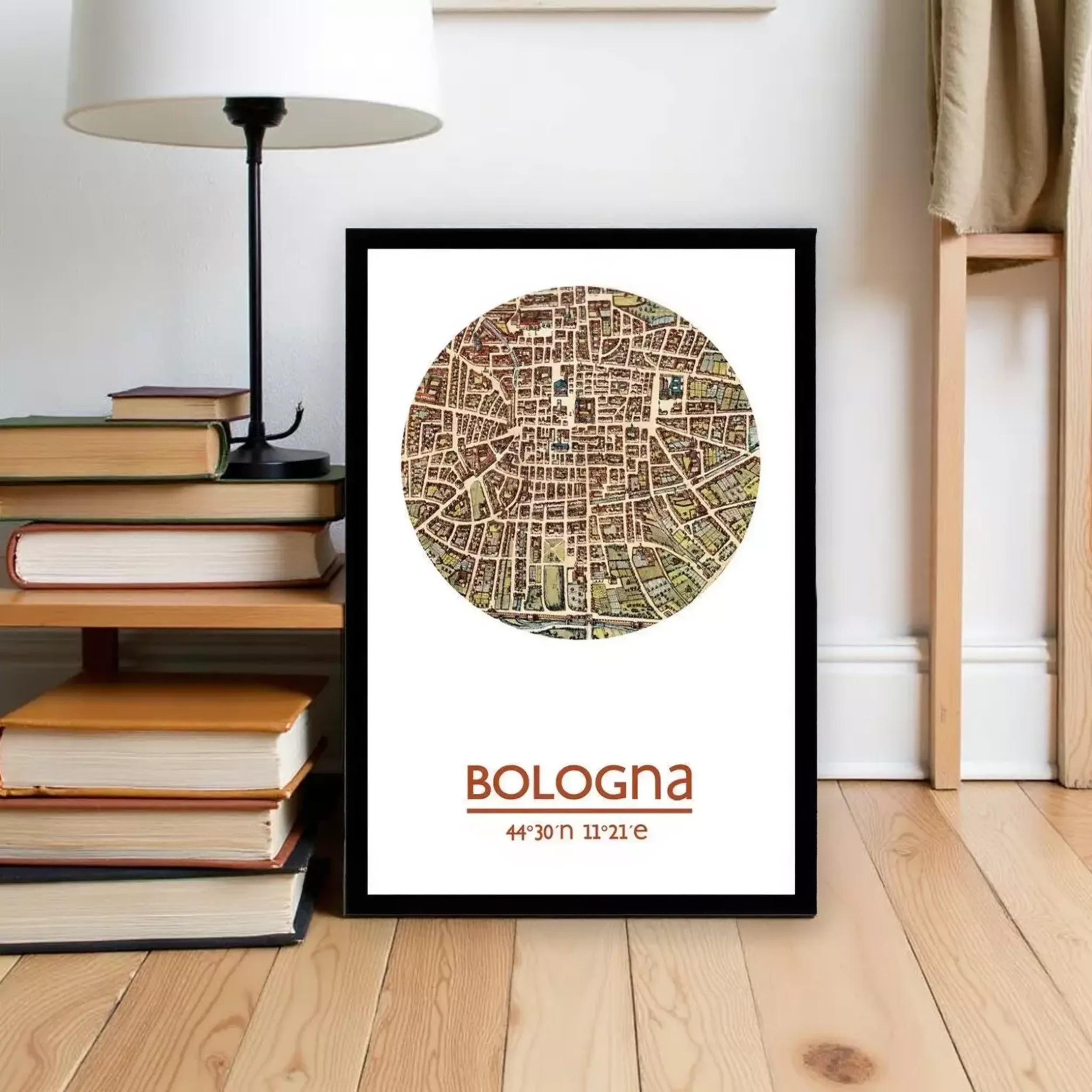 A framed map of Bologna, Italy, with the text "Bologna 44° 30' 11' 21"", placed on a wooden floor next to a stack of books and a lamp.
