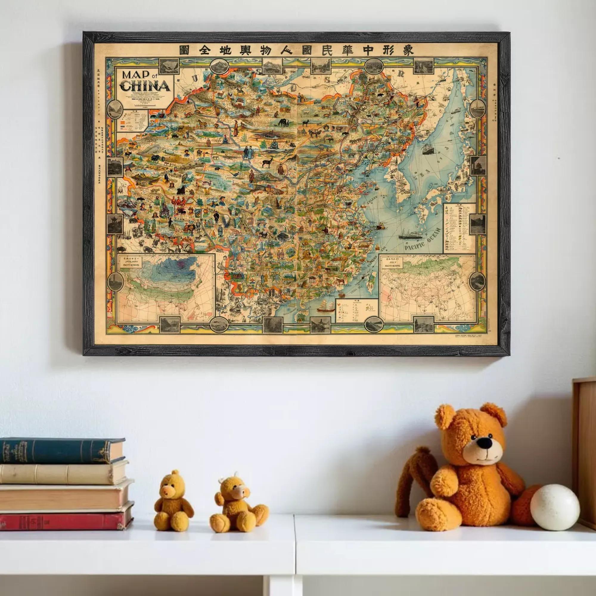 a framed map of China hanging on a wall, with a stack of books and two teddy bears placed below it.