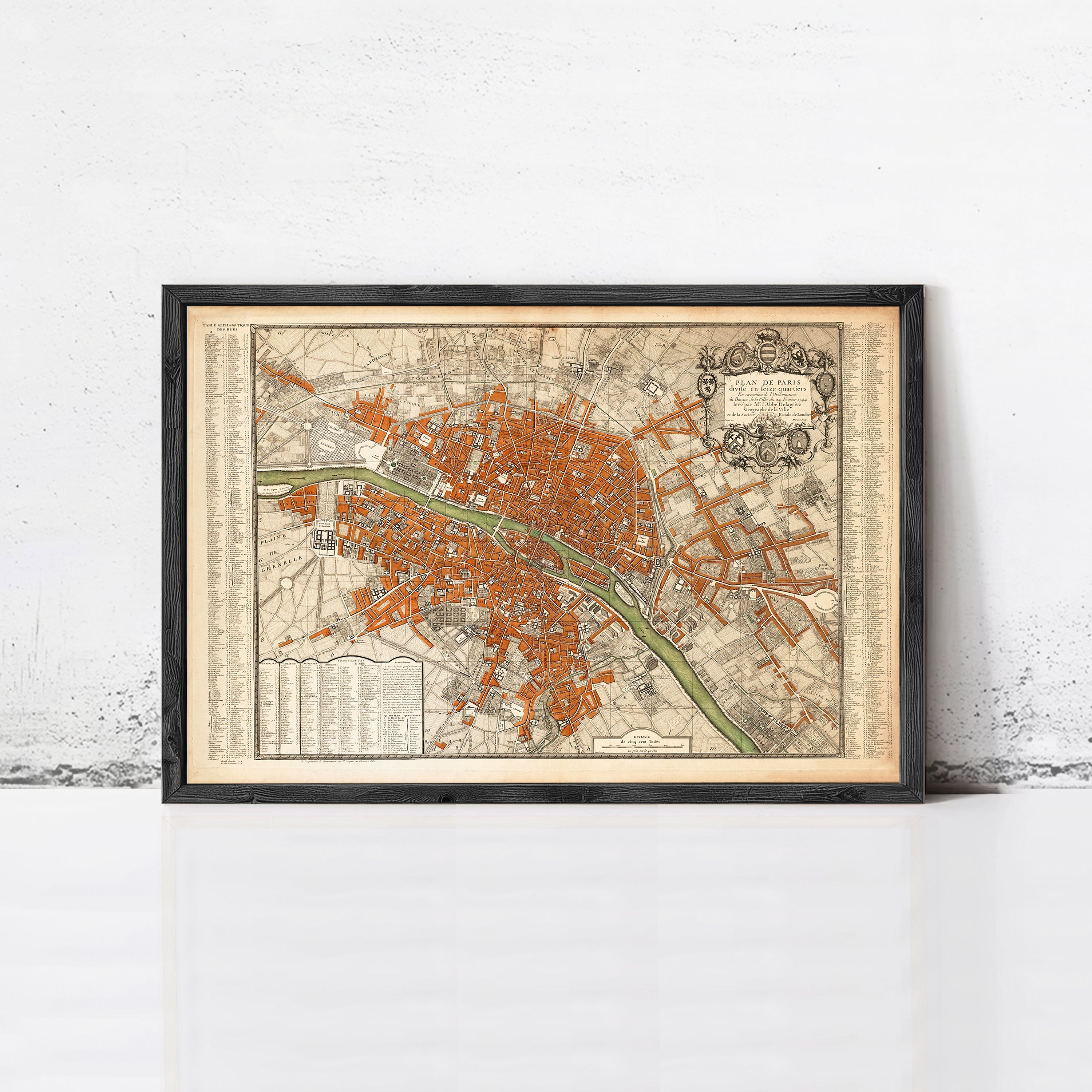 The image is a framed vintage map of a city, likely Paris, with a detailed and intricate design.