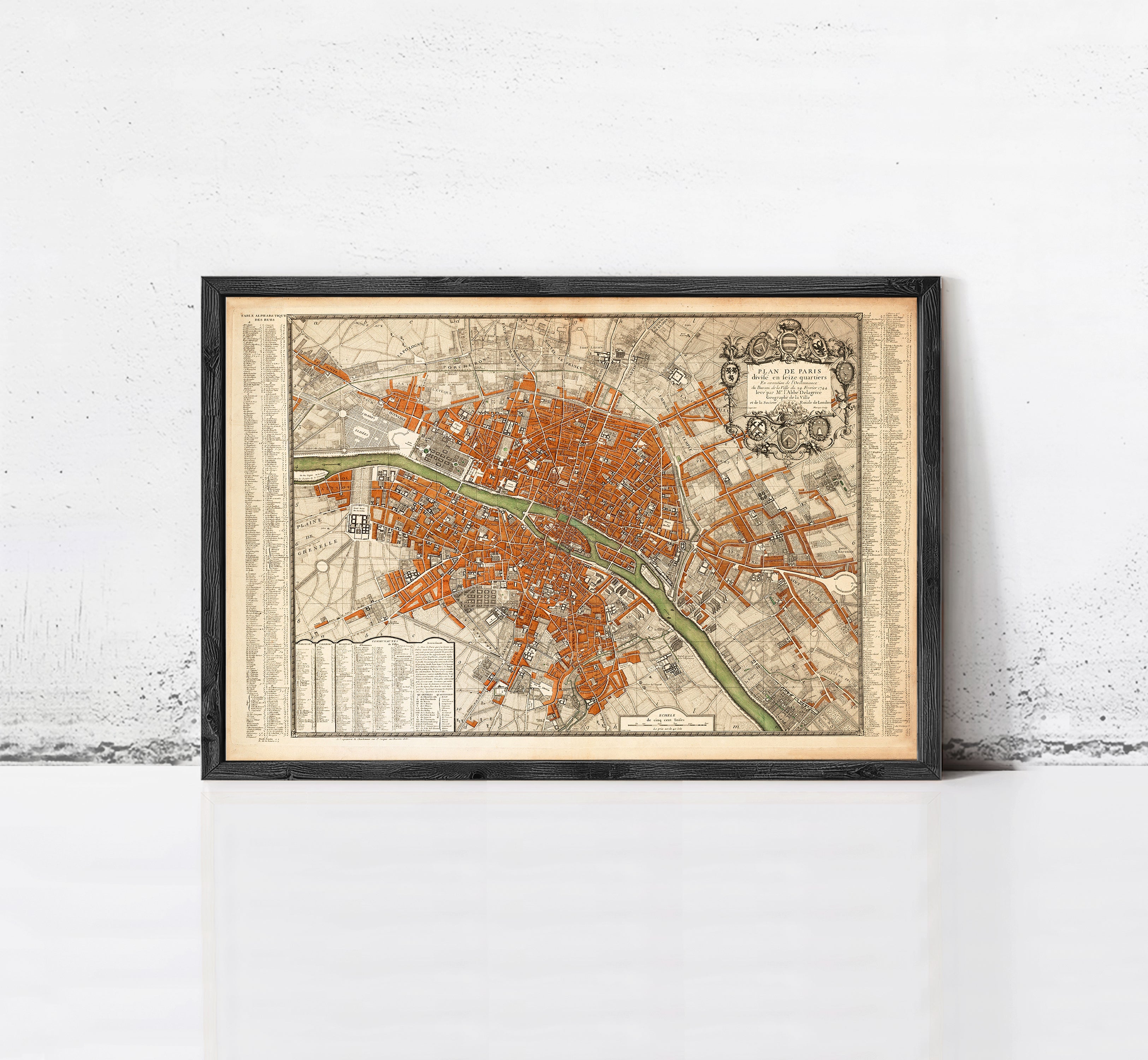 The image is a framed vintage map of a city, likely Paris, with a detailed and intricate design.
