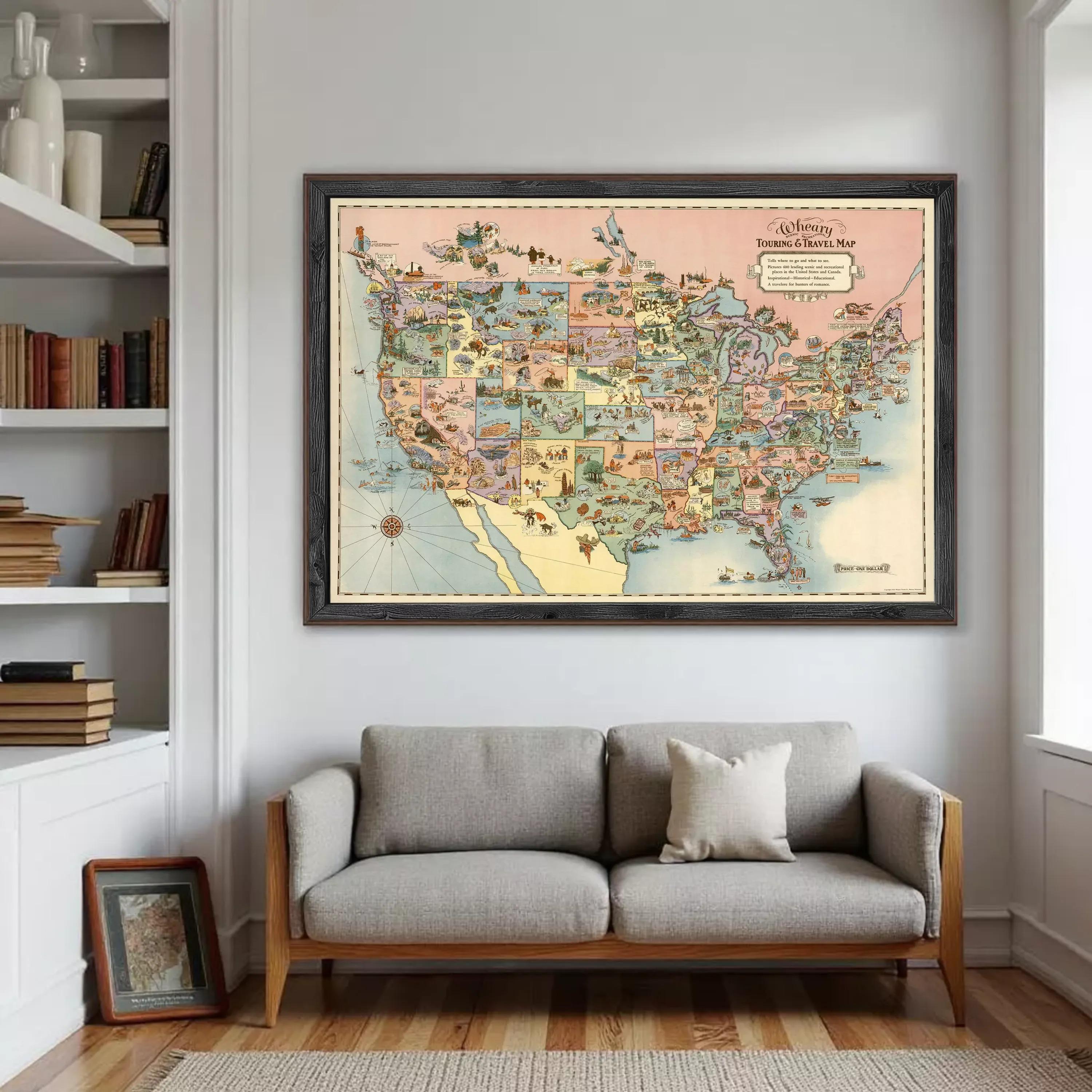 a large framed map of the United States hanging on a wall above a gray sofa in a living room.